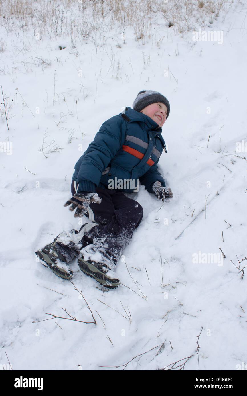 Im Winterschnee war ein Junge und schrie vor Schmerzen Stockfoto