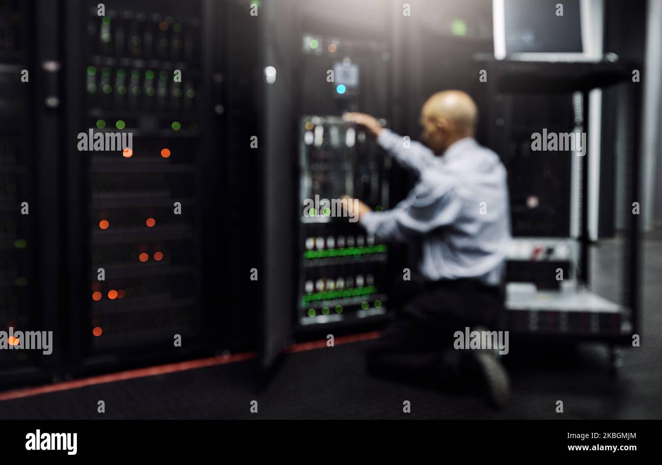 Er kennt sich mit einem Computersystem aus. Rückansicht eines IT-Technikers, der einen Computer in einem Rechenzentrum repariert. Stockfoto