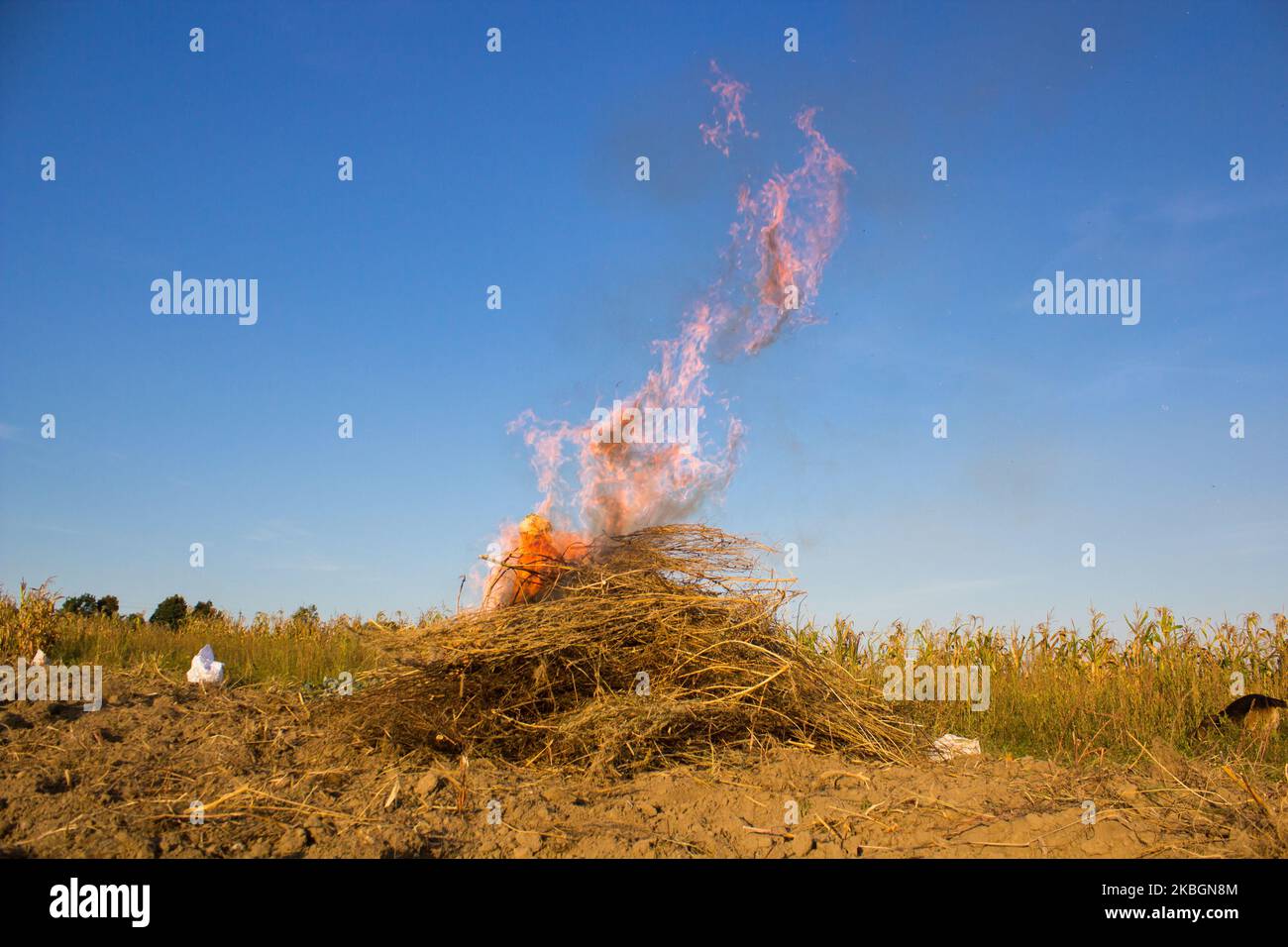 Der Haufen verbrennt im Feld des trockenen Heus im Herbst Stockfoto