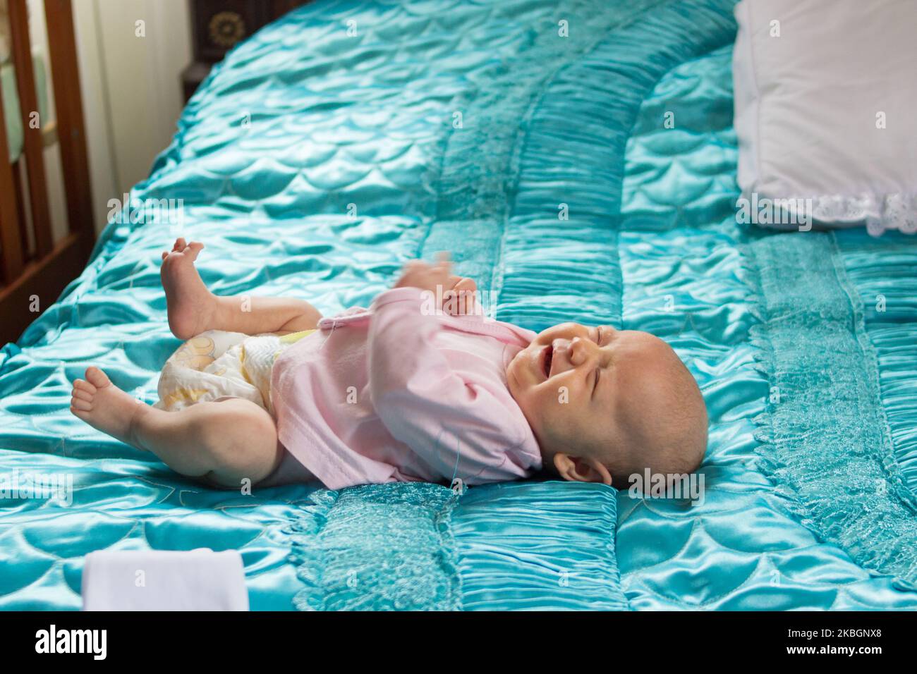 Baby liegt die Hungrigen und Weinen auf dem Bett Stockfoto