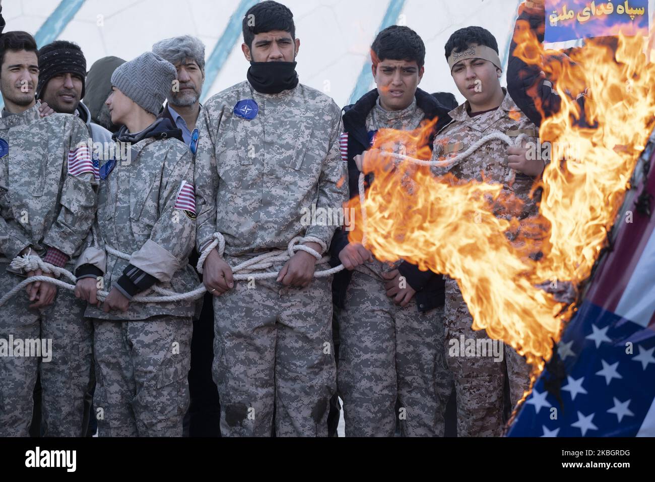 Iraner verbrennen einen symbolischen US-Sarg, während Schuljungen als US-Kriegsgefangene auftreten, während sie am 11. Februar 2020 an einer Kundgebung anlässlich des Jahrestages der Islamischen Revolution auf dem Azadi-Platz (Freiheit) im Westen Teherans teilnehmen. - Tausende von Iranern, die sich zum Gedenken an die 41 Jahre seit der Islamischen Revolution zusammenschlossen, in einer Zeit erhöhter Spannungen mit den Vereinigten Staaten, als Zeichen der Einheit. Die Feierlichkeiten markieren den Tag, an dem der schiitische Geistliche Khomeini aus dem Exil zurückkehrte und die letzte Regierung des schahs verdrängte. (Foto von Morteza Nikoubazl/NurPhoto) Stockfoto