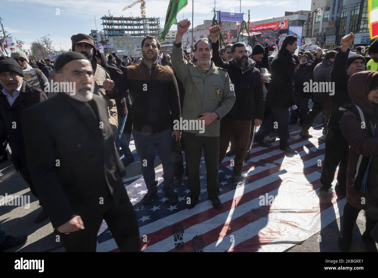 Ein Befehlshaber des iranischen Islamischen Revolutionsgarden-Korps (IRGC) ruft am 11. Februar 2020 auf dem Azadi-Platz im Westen Teherans Anti-US-Slogans, während er auf der US-Flagge steht, um den Jahrestag der Islamischen Revolution zu begehen. - Tausende von Iranern, die sich zum Gedenken an die 41 Jahre seit der Islamischen Revolution zusammenschlossen, in einer Zeit erhöhter Spannungen mit den Vereinigten Staaten, als Zeichen der Einheit. Die Feierlichkeiten markieren den Tag, an dem der schiitische Geistliche Khomeini aus dem Exil zurückkehrte und die letzte Regierung des schahs verdrängte. (Foto von Morteza Nikoubazl/NurPhoto) Stockfoto