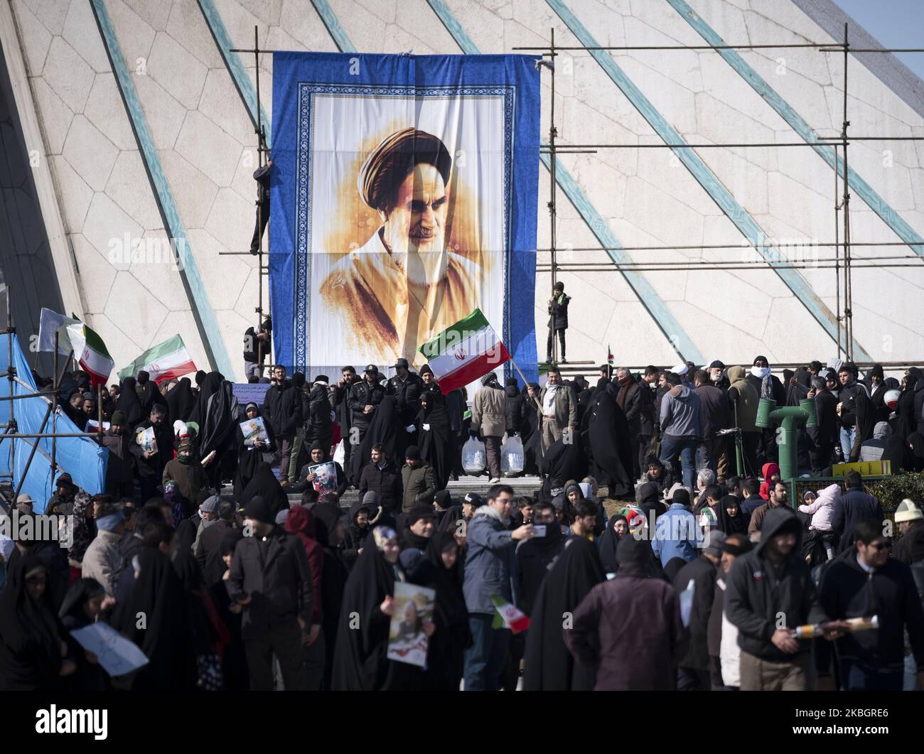 Die Iraner stehen unter einem riesigen Porträt des verstorbenen iranischen Führers Ayatollah Ruhollah Khomeini, als sie am 11. Februar 2020 an einer Kundgebung anlässlich des Jahrestages der Islamischen Revolution auf dem Azadi-Platz (Freiheit) im Westen Teherans teilnehmen. - Tausende von Iranern, die sich zum Gedenken an die 41 Jahre seit der Islamischen Revolution zusammenschlossen, in einer Zeit erhöhter Spannungen mit den Vereinigten Staaten, als Zeichen der Einheit. Die Feierlichkeiten markieren den Tag, an dem der schiitische Geistliche Khomeini aus dem Exil zurückkehrte und die letzte Regierung des schahs verdrängte. (Foto von Morteza Nikoubazl/NurPhoto) Stockfoto