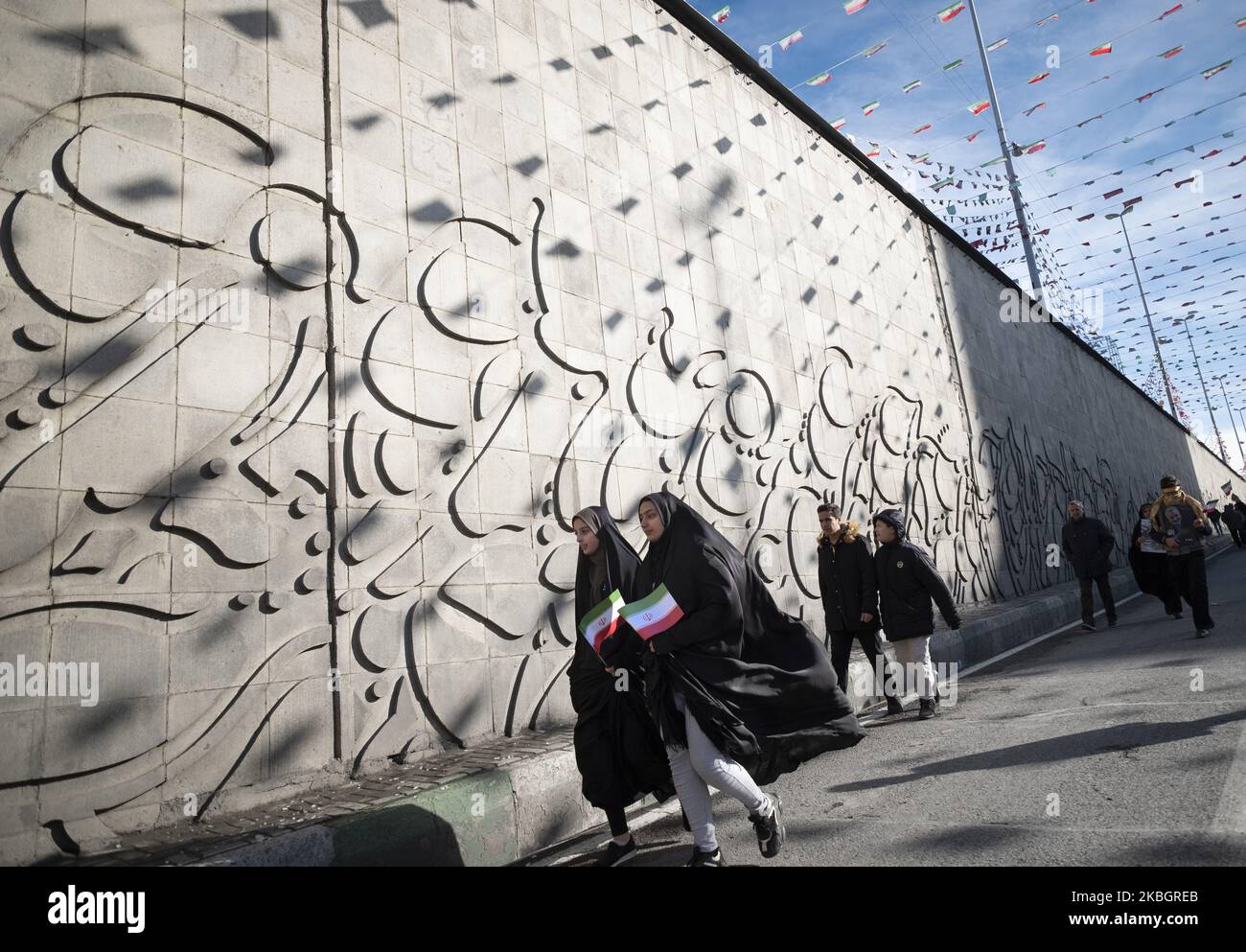 Zwei verschleierte iranische Frauen gehen entlang der Azadi (Freedom) Avenue, während sie während einer Kundgebung zum Jahrestag der Islamischen Revolution im Westen Teherans am 11. Februar 2020 iranische Flaggen tragen. - Tausende von Iranern, die sich zum Gedenken an die 41 Jahre seit der Islamischen Revolution zusammenschlossen, in einer Zeit erhöhter Spannungen mit den Vereinigten Staaten, als Zeichen der Einheit. Die Feierlichkeiten markieren den Tag, an dem der schiitische Geistliche Khomeini aus dem Exil zurückkehrte und die letzte Regierung des schahs verdrängte. (Foto von Morteza Nikoubazl/NurPhoto) Stockfoto