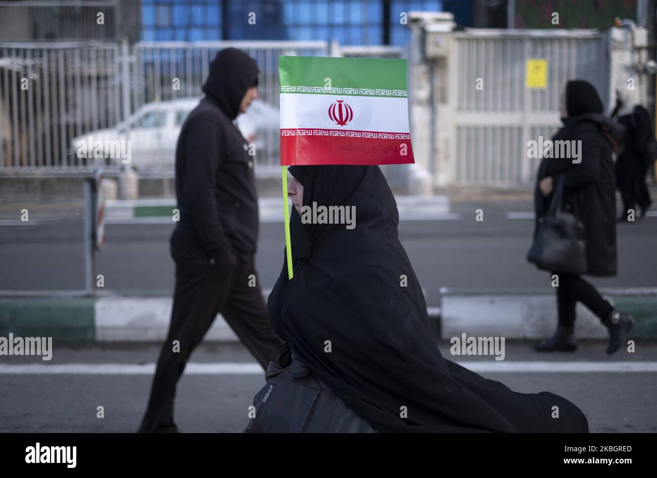 Eine verschleierte iranische Frau geht entlang der Azadi (Freedom) Avenue, während er während einer Kundgebung zum Jahrestag der Islamischen Revolution im Westen Teherans am 11. Februar 2020 eine iranische Flagge trägt. - Tausende von Iranern, die sich zum Gedenken an die 41 Jahre seit der Islamischen Revolution zusammenschlossen, in einer Zeit erhöhter Spannungen mit den Vereinigten Staaten, als Zeichen der Einheit. Die Feierlichkeiten markieren den Tag, an dem der schiitische Geistliche Khomeini aus dem Exil zurückkehrte und die letzte Regierung des schahs verdrängte. (Foto von Morteza Nikoubazl/NurPhoto) Stockfoto