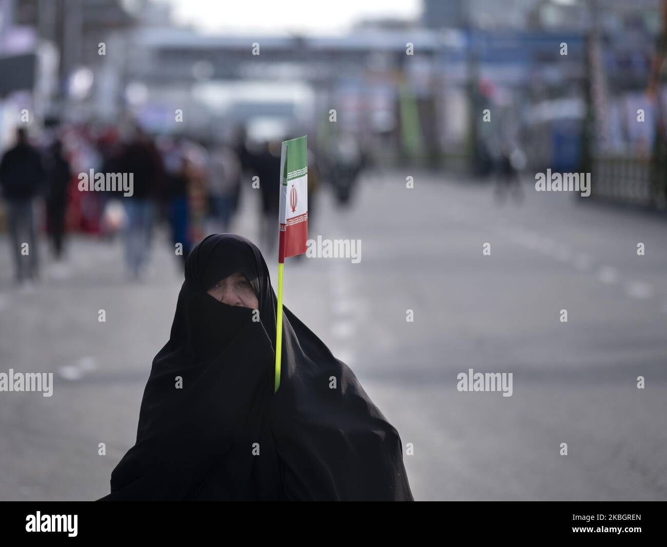 Eine verschleierte iranische Frau geht entlang der Azadi (Freedom) Avenue, während er während einer Kundgebung zum Jahrestag der Islamischen Revolution im Westen Teherans am 11. Februar 2020 eine iranische Flagge trägt. - Tausende von Iranern, die sich zum Gedenken an die 41 Jahre seit der Islamischen Revolution zusammenschlossen, in einer Zeit erhöhter Spannungen mit den Vereinigten Staaten, als Zeichen der Einheit. Die Feierlichkeiten markieren den Tag, an dem der schiitische Geistliche Khomeini aus dem Exil zurückkehrte und die letzte Regierung des schahs verdrängte. (Foto von Morteza Nikoubazl/NurPhoto) Stockfoto