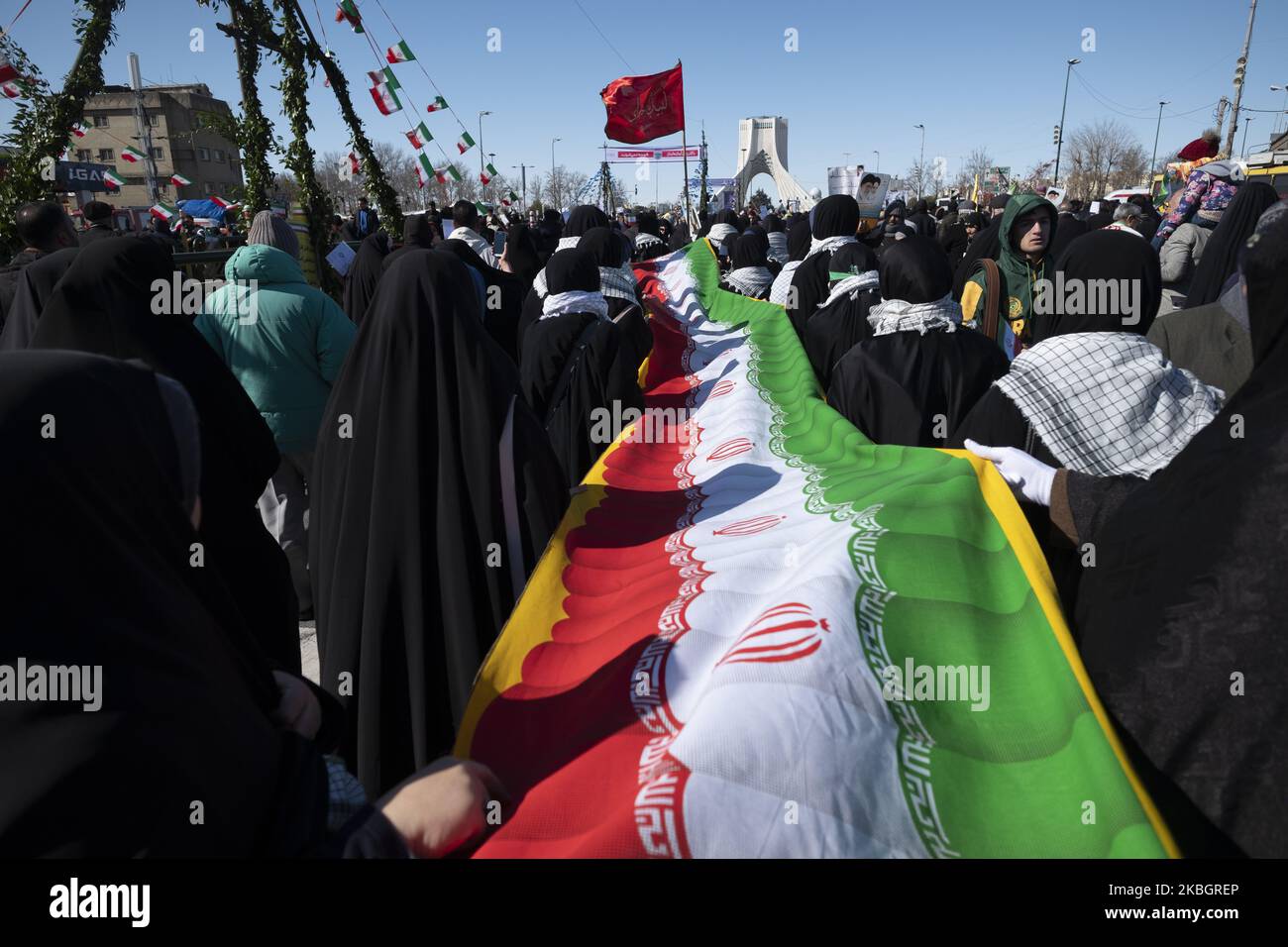 Iranische Schülerinnen, die am 11. Februar 2020 auf dem Azadi-Platz (Freiheit) im Westen Teherans eine iranische Flagge entlang einer Allee zum Azadi-Platz (Freiheits-)tragen, während einer Kundgebung anlässlich des Jahrestages der Islamischen Revolution. - Tausende von Iranern, die sich zum Gedenken an die 41 Jahre seit der Islamischen Revolution zusammenschlossen, in einer Zeit erhöhter Spannungen mit den Vereinigten Staaten, als Zeichen der Einheit. Die Feierlichkeiten markieren den Tag, an dem der schiitische Geistliche Khomeini aus dem Exil zurückkehrte und die letzte Regierung des schahs verdrängte. (Foto von Morteza Nikoubazl/NurPhoto) Stockfoto
