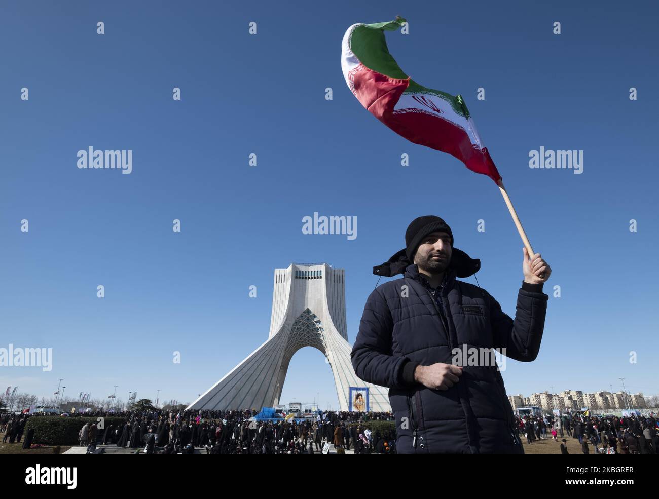 Am 11. Februar 2020 winkt ein Iraner mit einer iranischen Flagge, als er an einer Kundgebung anlässlich des Jahrestages der Islamischen Revolution auf dem Azadi-Platz (Freiheit) im Westen Teherans teilnimmt. - Tausende von Iranern, die sich zum Gedenken an die 41 Jahre seit der Islamischen Revolution zusammenschlossen, in einer Zeit erhöhter Spannungen mit den Vereinigten Staaten, als Zeichen der Einheit. Die Feierlichkeiten markieren den Tag, an dem der schiitische Geistliche Khomeini aus dem Exil zurückkehrte und die letzte Regierung des schahs verdrängte. (Foto von Morteza Nikoubazl/NurPhoto) Stockfoto