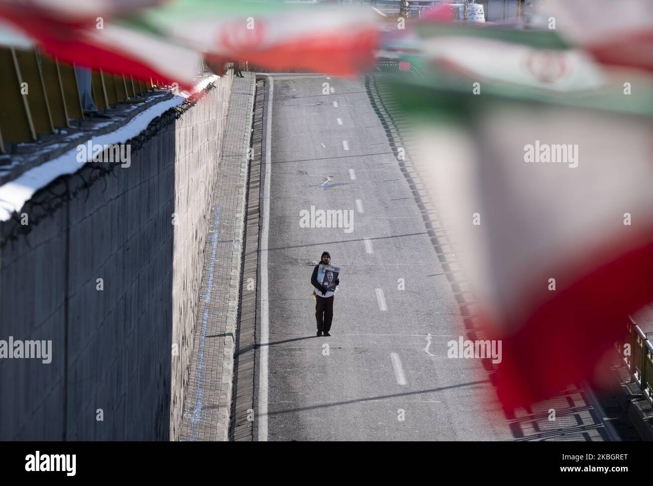 Ein Iraner geht entlang der Azadi (Freedom) Avenue und trägt ein Porträt der ehemaligen Qasem Soleimani, eines Korps der islamischen Revolutionsgarden, während einer Kundgebung anlässlich des Jahrestages der Islamischen Revolution im Westen Teherans am 11. Februar 2020. - Tausende von Iranern, die sich zum Gedenken an die 41 Jahre seit der Islamischen Revolution zusammenschlossen, in einer Zeit erhöhter Spannungen mit den Vereinigten Staaten, als Zeichen der Einheit. Die Feierlichkeiten markieren den Tag, an dem der schiitische Geistliche Khomeini aus dem Exil zurückkehrte und die letzte Regierung des schahs verdrängte. (Foto von Morteza Nikoubazl/NurPhoto) Stockfoto