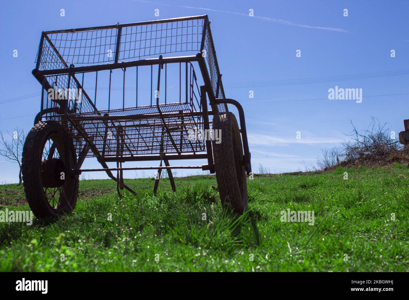 Leerer Metallwagen auf zwei Rädern auf dem Gras Stockfoto