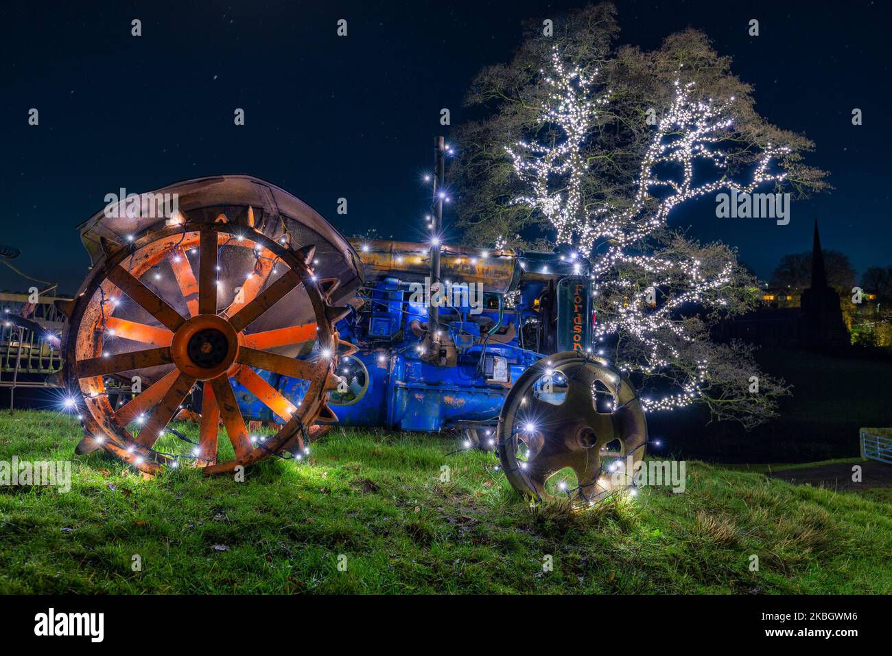 Traktor mit LED-Leuchten und LED-überdachtem Baum im Hintergrund Stockfoto