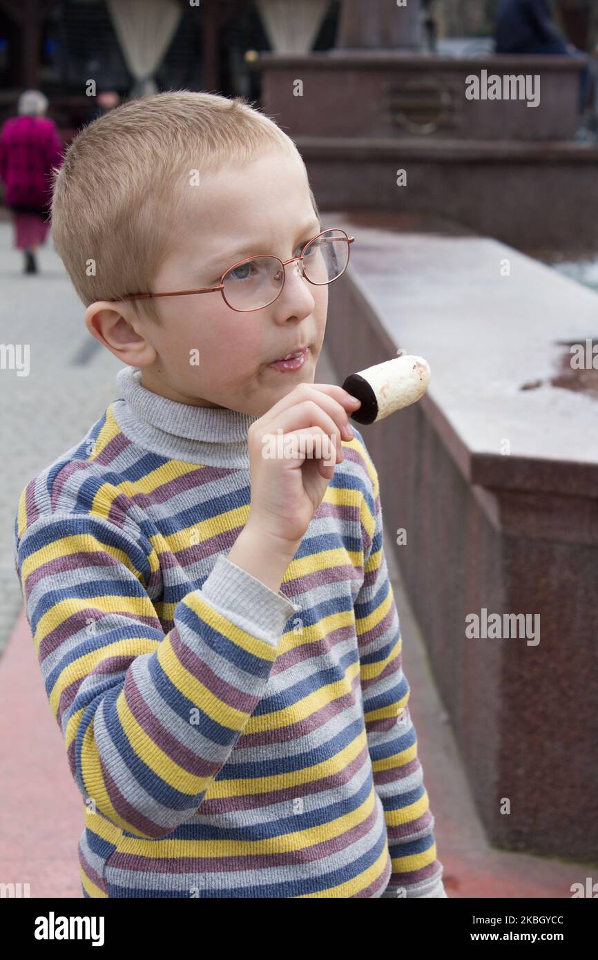 Trauriger Junge isst im Frühling Eis Stockfoto