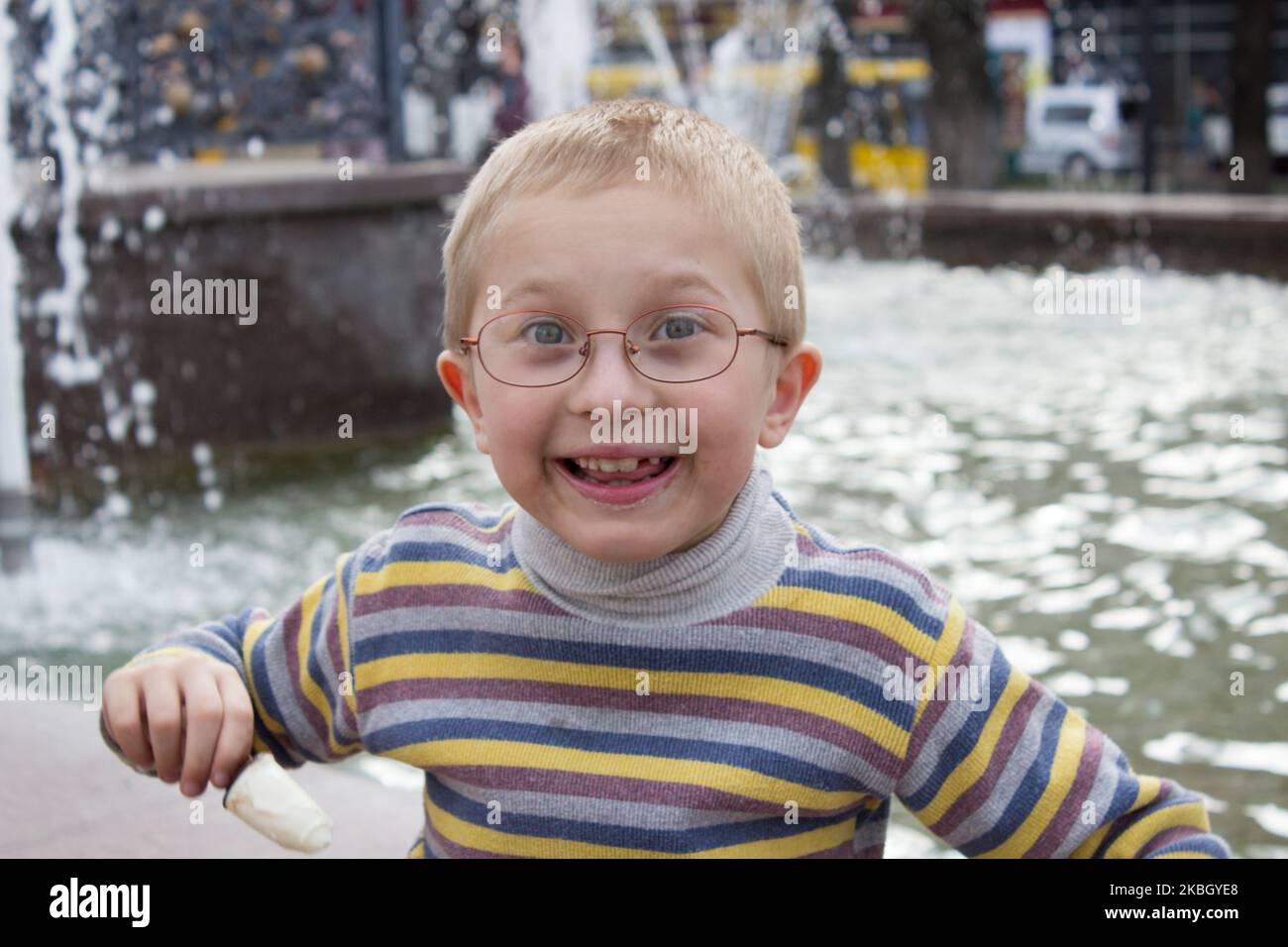 Fröhlicher Junge lachend im Hintergrund Brunnen Stockfoto