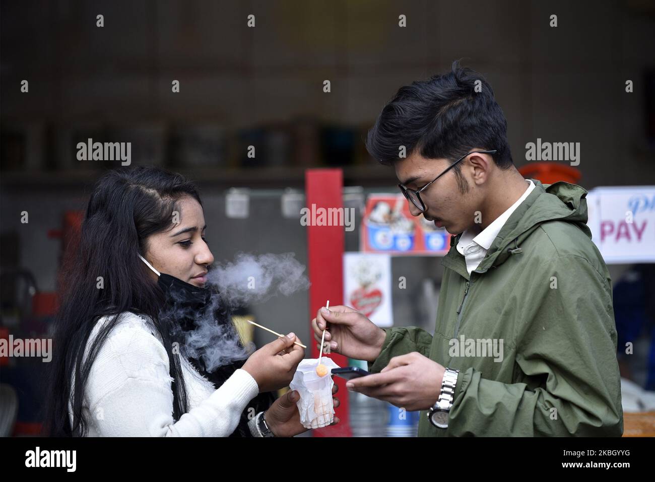 Ein Paar, das am Freitag, den 14. Februar 2020, während der Feier des Valentinstag in der Civil Mall, Kathmandu, Nepal, Flüssigstickstoff-Käsebälle isst. Blumenläden im Kathmandu Valley haben Tausende von Rosenstöcken für den Valentinstag vorbereitet. Nepal importierte 130.000 rote Rosen, ein Symbol der Liebe im Wert von Rs10 Millionen aus Indien, um den Valentinstag zu feiern. (Foto von Narayan Maharjan/NurPhoto) Stockfoto