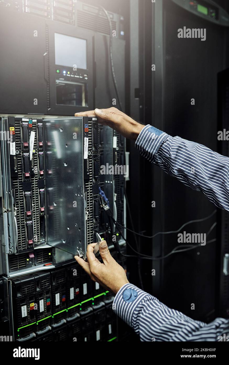 Fachkundige Hände kümmern sich um die Hardware-Reparatur. Ein nicht erkennbarer IT-Techniker repariert einen Computer in einem Rechenzentrum. Stockfoto