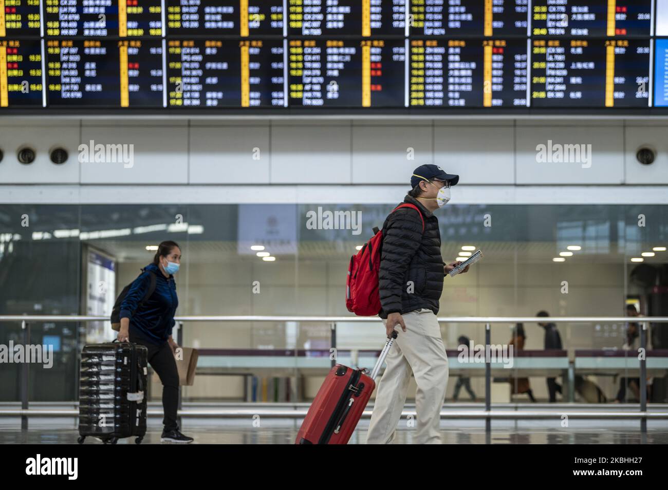 Passagiere, die eine Maske tragen, werden am 22. Februar 2020 in Hongkong an einer Anzeigetafel für Fluginformationen in der Ankunftshalle im Terminal des internationalen Flughafens von Hongkong vorbeigehen sehen. China. Das Coronavirus oder Covid-19, das aus Wuhan China stammt, hat sich weltweit über 77.000 infiziert und 2361 Menschen getötet. Die Passagierflüge nach und aus Hongkong sind um zwei Drittel zurückgegangen, und die Fluggesellschaften haben Flüge storniert, und die Reisenden sind wegen des Coronavirus in Hongkong abgestürzt. (Foto von Vernon Yuen/NurPhoto) Stockfoto