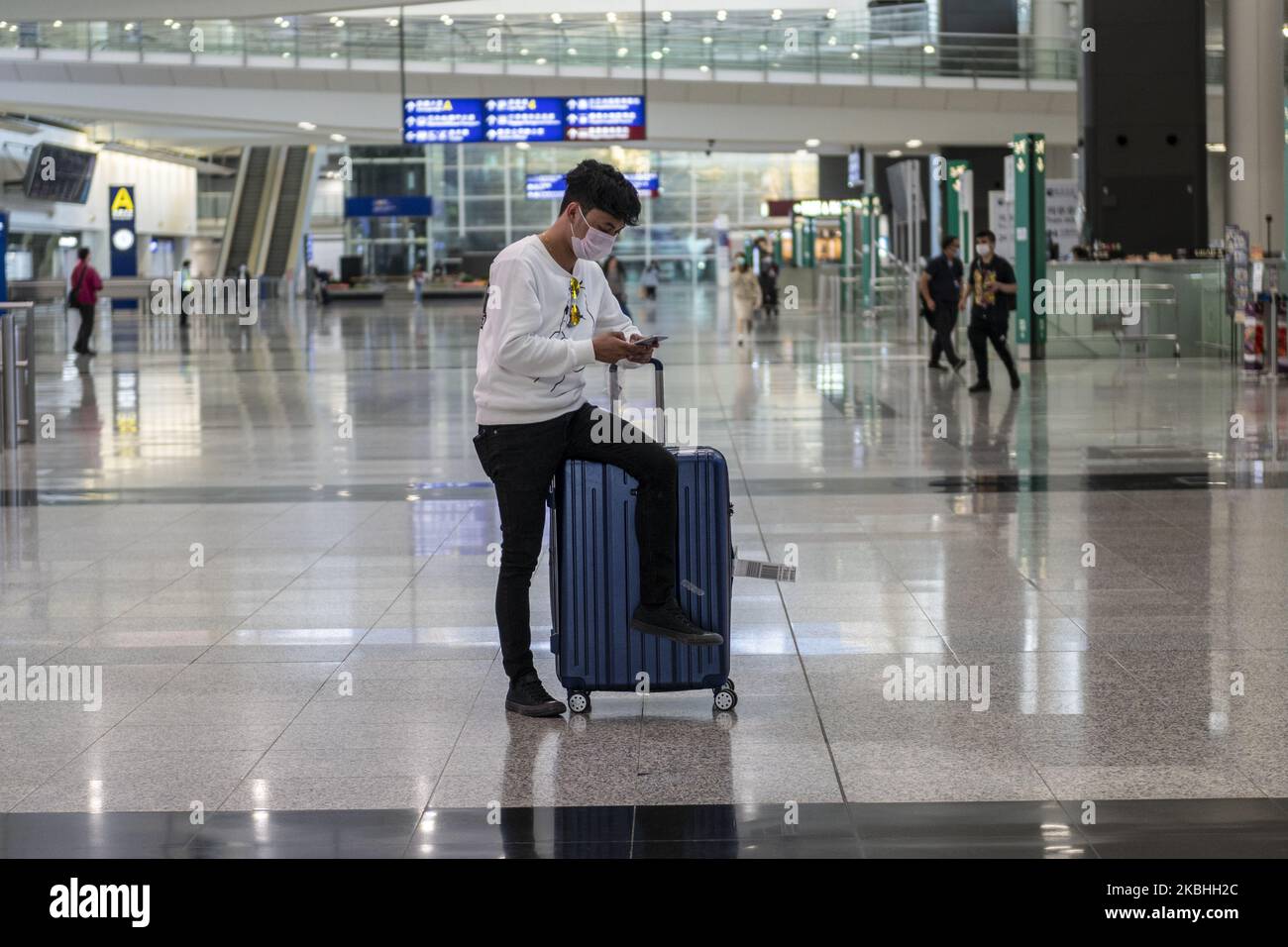 Am 22. Februar 2020 sitzt ein Mann mit einer Maske auf einem Gepäck im Terminal des Internationalen Flughafens von Hongkong in Hongkong, China. Das Coronavirus oder Covid-19, das aus Wuhan, China stammt, hat bis heute über 77.000 Menschen infiziert und 2361 Menschen weltweit getötet. Die Passagierflüge nach und aus Hongkong sind um zwei Drittel zurückgefallen, da die Fluggesellschaften Flüge annulliert haben und die Reisenden aufgrund des Coronavirus in Hongkong stürzte. (Foto von Vernon Yuen/NurPhoto) Stockfoto