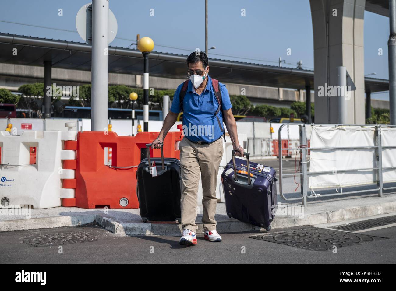 Ein Mann mit Maske zieht am 22. Februar 2020 in Hongkong, China, zwei Gepäckwagen auf dem Internationalen Flughafen Hongkong. Das Coronavirus oder Covid-19, das aus Wuhan, China stammt, hat bis heute über 77.000 infiziert und 2361 weltweit getötet. Die Passagierflüge nach und aus Hongkong sind um zwei Drittel zurückgefallen, da die Fluggesellschaften Flüge annulliert haben und die Reisenden aufgrund des Coronavirus in Hongkong stürzte. (Foto von Vernon Yuen/NurPhoto) Stockfoto