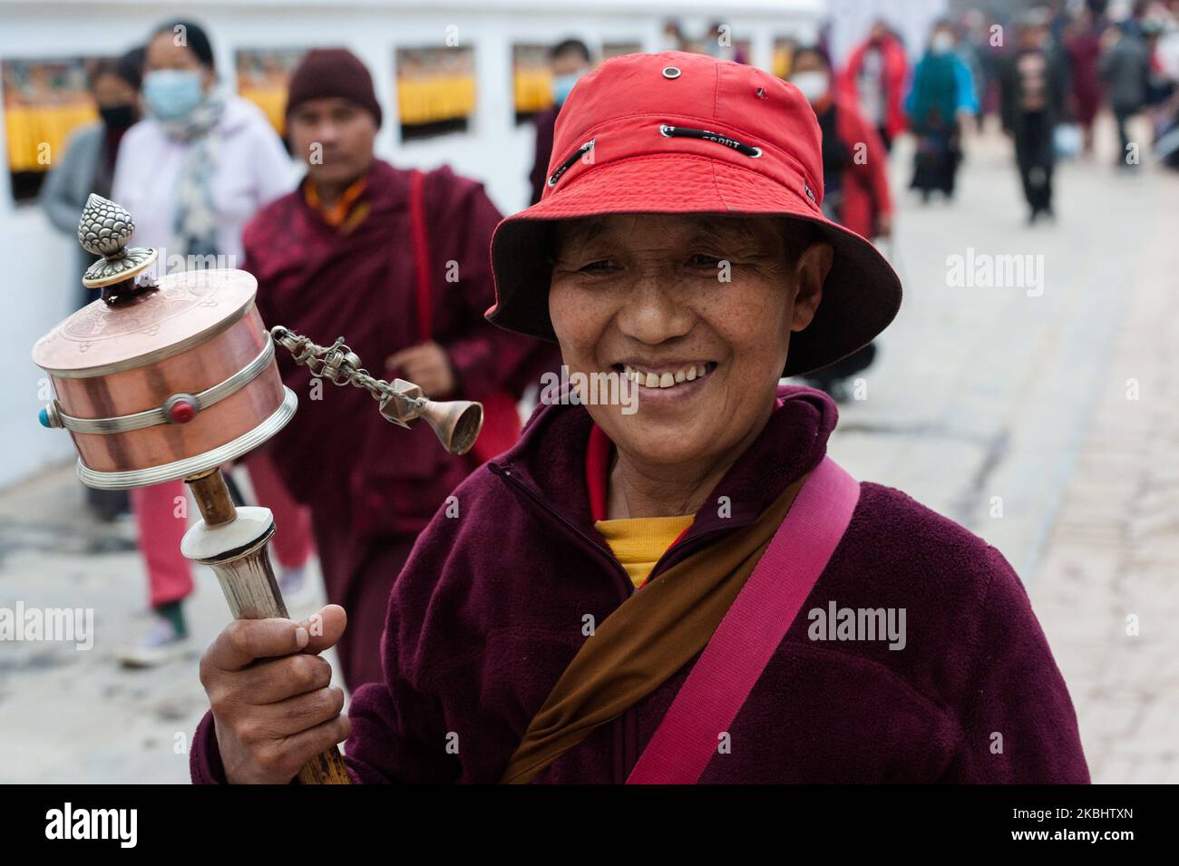 Eine Frau, die eine tibetisch-buddhistische kastanienbraune Mönchsrobe trägt, dreht ein handliches Gebetsrad, während sie am ersten Tag der tibetischen Neujahrsfeier (Losar) am 24. Februar 2020 in Kathmandu, Nepal, die „Kora“, eine rituelle Umrundung der Boudhanath-Stupa, durchführt. Die Boudhanath Stupa ist ein UNESCO-Weltkulturerbe und das wichtigste tibetisch-buddhistische Monument außerhalb Tibets. (Foto von Wiktor Szymanowicz/NurPhoto) Stockfoto