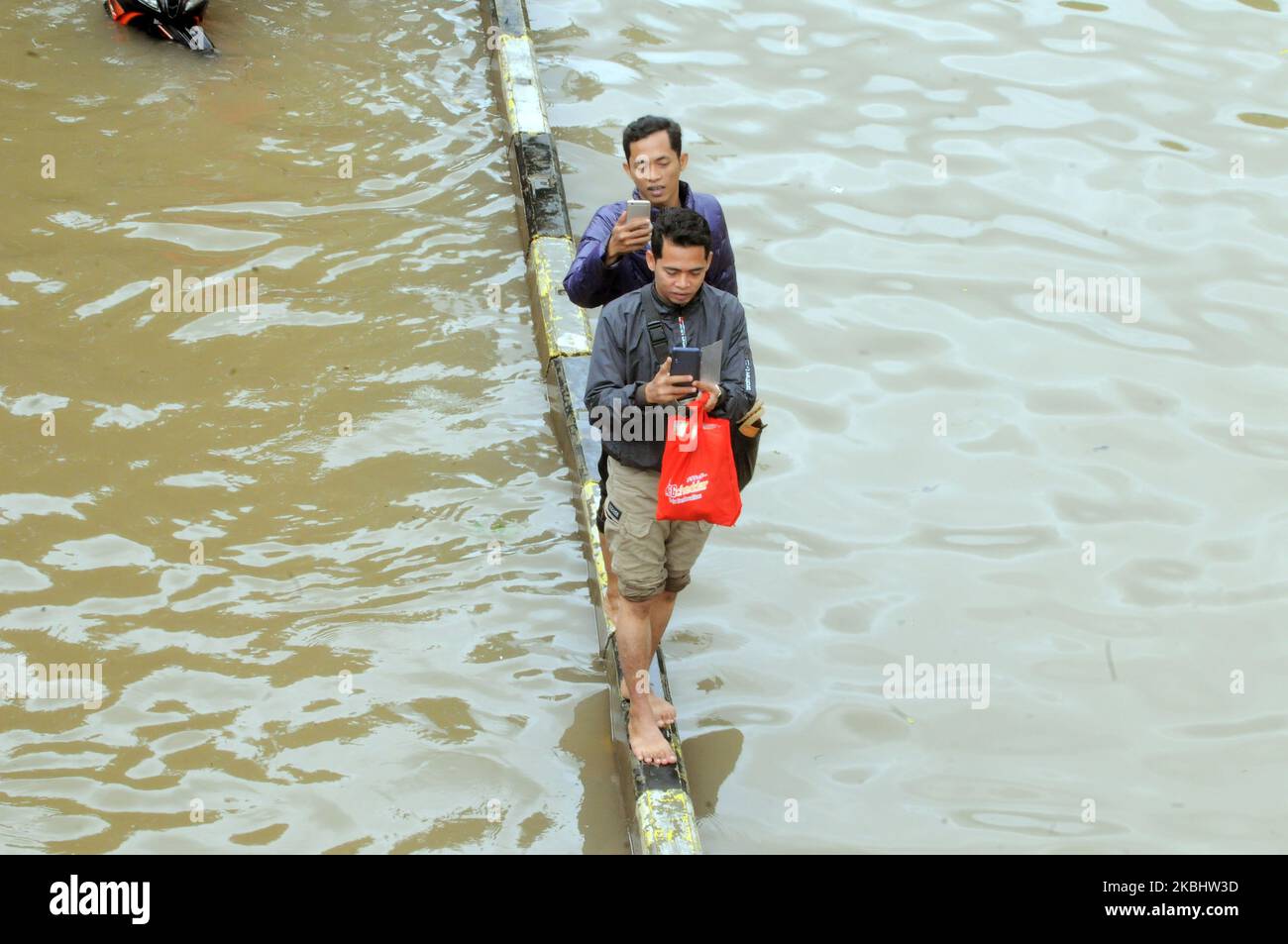 Menschen waten durch Hochwasser, nachdem am 25. Februar 2020 heftige Regenfälle in Jakarta, Indonesien, eintrafen. (Foto von Dasril Roszandi/NurPhoto) Stockfoto