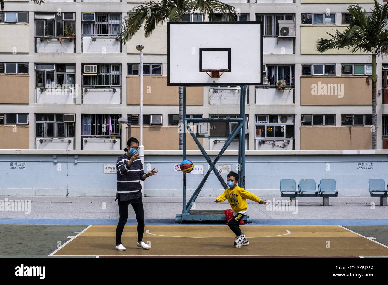 Eine Frau und ein Junge tragen eine Maske, als sie am 27. Februar 2020 in Hongkong, China, Basketball spielen. Das Coronavirus oder Covid-19, das aus Wuhan China stammt, hat bis heute über 82.000 infiziert und 2810 weltweit getötet. (Foto von Vernon Yuen/NurPhoto) Stockfoto