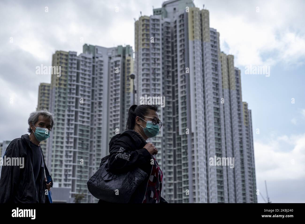 Am 27. Februar 2020 in Hongkong, China, werden maskierte Menschen am Wohnhausgebäude vorbeilaufen sehen. Das Coronavirus oder Covid-19, das aus Wuhan China stammt, hat bis heute über 82.000 Menschen infiziert und 2810 Menschen weltweit getötet. (Foto von Vernon Yuen/NurPhoto) Stockfoto