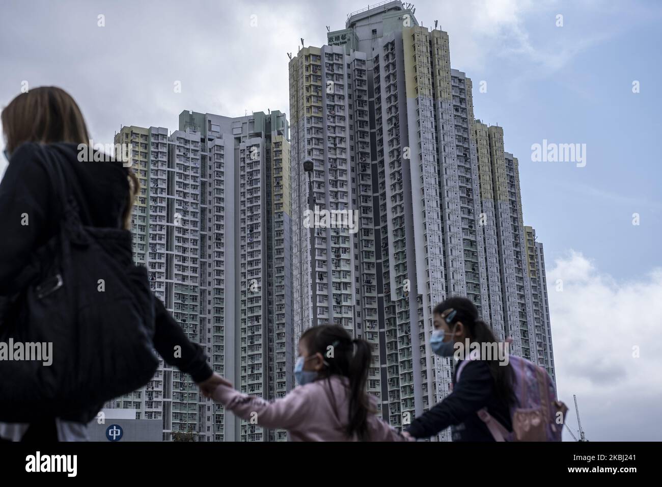 Am 27. Februar 2020 passieren Frauen, die maskierte Kinder tragen, in Hongkong ein Wohngebäude. Das Coronavirus oder Covid-19, das aus Wuhan China stammt, hat bis heute über 82.000 Menschen infiziert und 2810 Menschen weltweit getötet. (Foto von Vernon Yuen/NurPhoto) Stockfoto