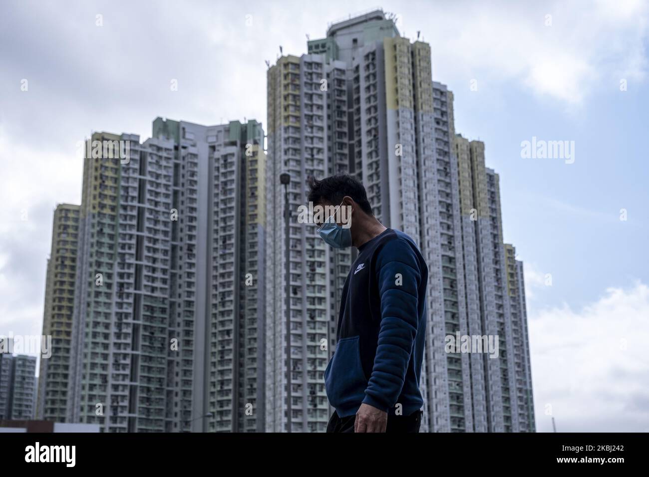 Am 27. Februar 2020 wird in Hongkong, China, ein Mann mit Maske am Wohnhausgebäude vorbeilaufen sehen. Das Coronavirus oder Covid-19, das aus Wuhan China stammt, hat bis heute über 82.000 infiziert und 2810 weltweit getötet. (Foto von Vernon Yuen/NurPhoto) Stockfoto