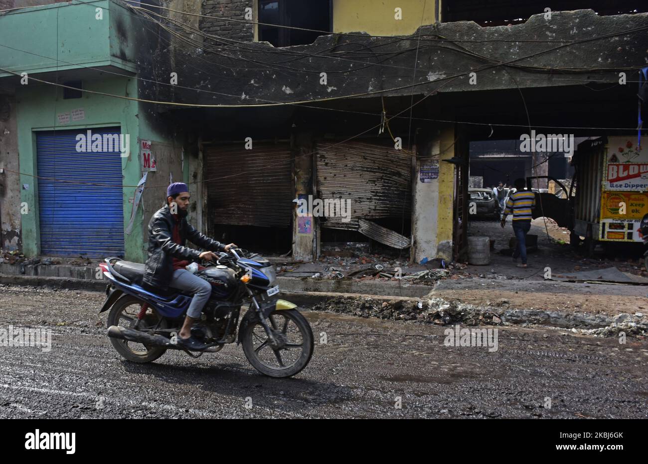 Ein Biker zieht an Geschäften vorbei, die von einem wütenden Mob bei einer jüngsten Gewalt in der Gegend von Mustafa Abad in Neu-Delhi am 29. Februar 2020 in Brand gesetzt wurden. Die Zahl der Todesopfer ist auf mehr als 40 Menschen gestiegen. Berichten zufolge wurden Hunderte von Personen verletzt und Hunderttausende von Eigentum wurden bei der Gewalt beschädigt, die letzte Woche in Indiens nationaler Hauptstadt Delhi wegen des umstrittenen Citizenship Amendment Act ausbrach. (Foto von Faisal Khan/NurPhoto) Stockfoto