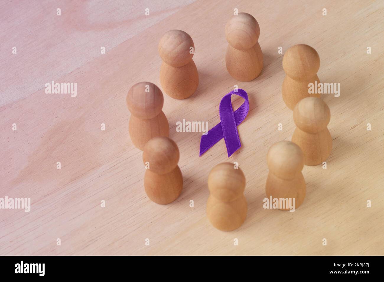 Holzpfand in einem Kreis um violettes Band - Konzept der häuslichen Gewalt Bewusstsein; Alzheimer-Krankheit, Bauchspeicheldrüsenkrebs, Epilepsie Bewusstsein und Stockfoto