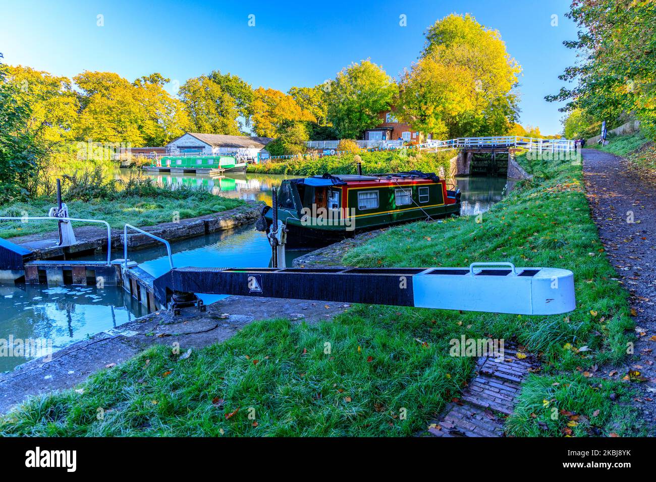 Ein kleines Schmalboot, das im Herbst auf dem Kennet & Avon Canal, bei Devizes, Wiltshire, England, in eine der 29 Schleusen in Caen Hill einfährt Stockfoto