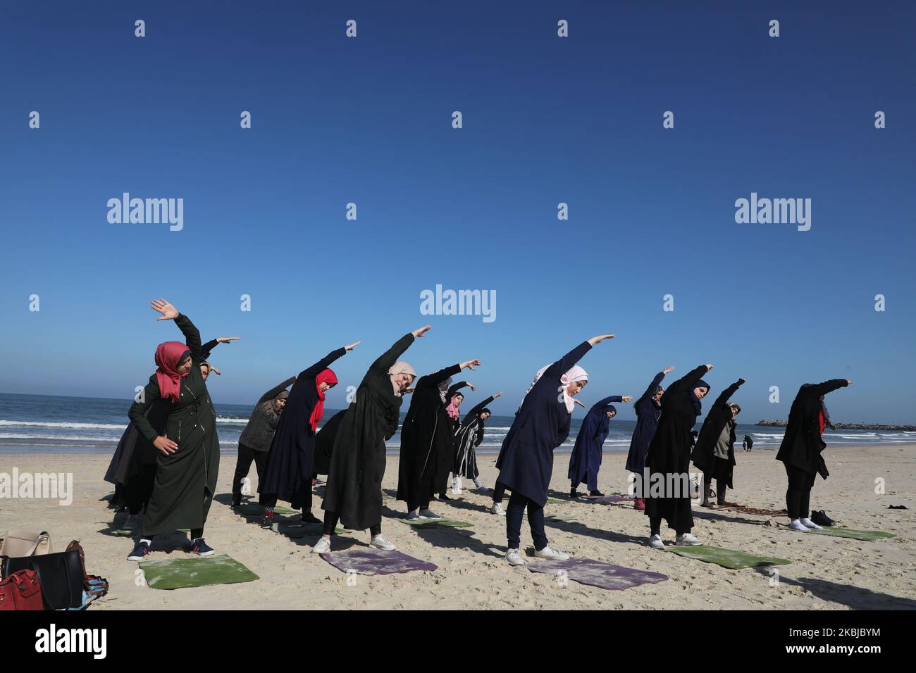 Palästinensische Frauen praktizieren am 3. März 2020 am Strand in Gaza City Yoga während einer Veranstaltung, die vom positiven Energieclub organisiert wird. (Foto von Majdi Fathi/NurPhoto) Stockfoto