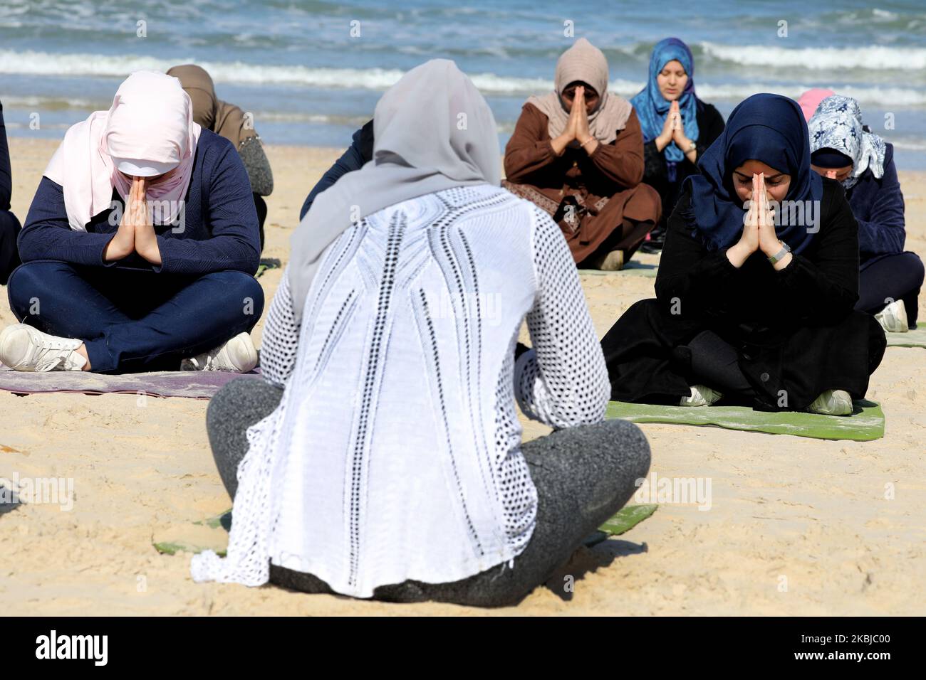 Palästinensische Frauen praktizieren am 3. März 2020 am Strand in Gaza City Yoga während einer Veranstaltung, die vom positiven Energieclub organisiert wird. (Foto von Majdi Fathi/NurPhoto) Stockfoto