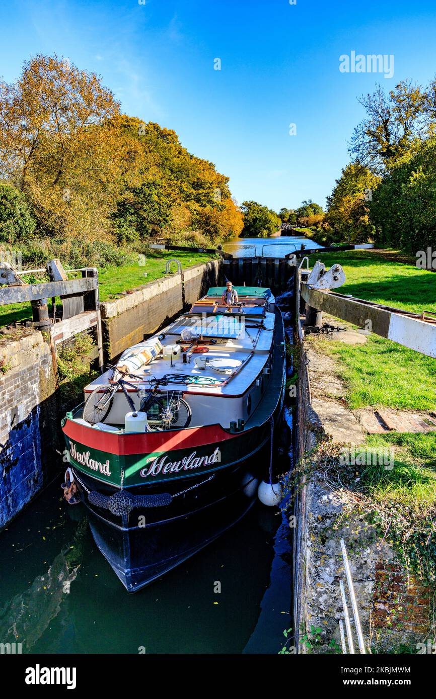 Ein „holländischer“ Lastkahn, der im Herbst durch eine der 29 Schleusen am Caen Hill auf dem Kennet & Avon Canal, bei Devizes, Wiltshire, England, Großbritannien, fährt Stockfoto