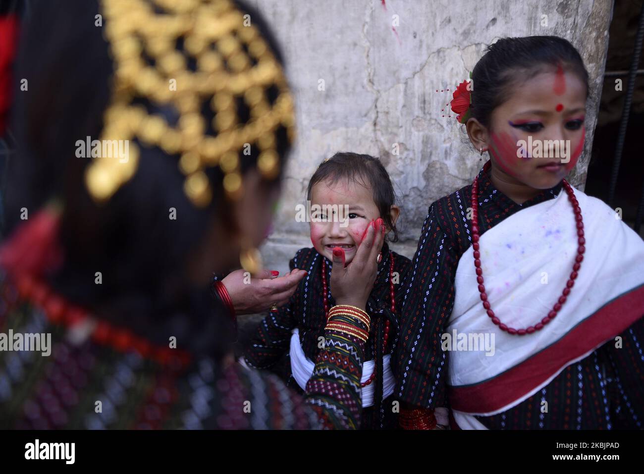 Ein nepalesisches Mädchen in traditioneller Kleidung schmierte dem kleinen Mädchen während der Holi- oder Fagu-Purnima-Feierlichkeiten, den Farbfestivals in Kirtipur, Kathmandu, Nepal, am Montag, den 09. März 2020, farbenfrohes Pulver. Die Menschen feiern Holi in ganz Nepal sowie in Indien. (Foto von Narayan Maharjan/NurPhoto) Stockfoto