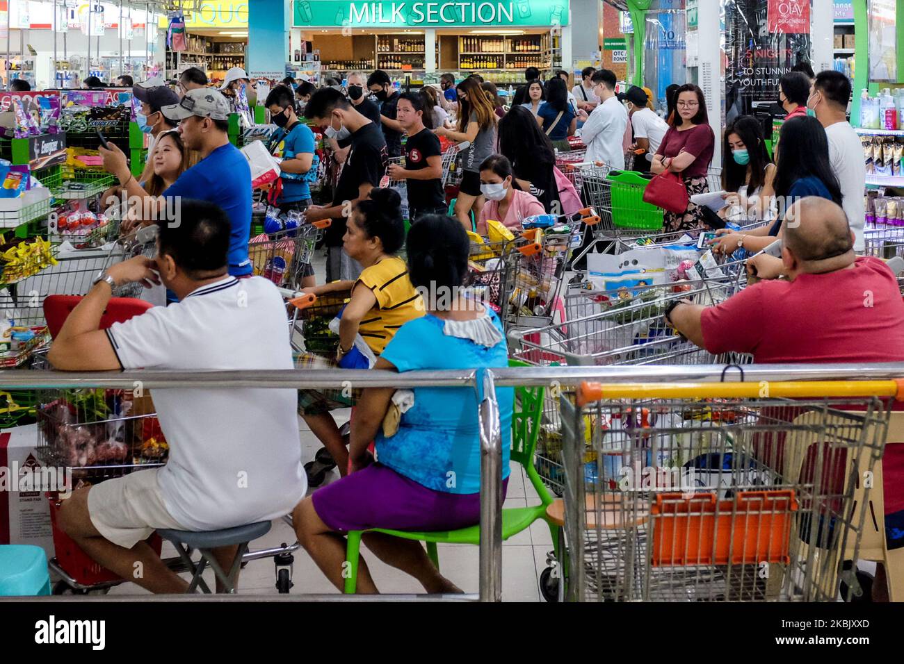 In einem Supermarkt in Pasig City, östlich von Manila, stehen Menschen Schlange, als sie am 13. März 2020 eilig Waren kaufen. Am 12. März erklärte Präsident Rodrigo Duterte in der Metro Manila eine Quarantäne für die Gemeinschaft, die Massenversammlungen Verbot, Klassen für einen Monat aussetzte und am Sonntag, dem 15. März, den ein- und Ausreisemeweg zu Land, zu Wasser und zu inländischen Flugreisen aus der Region der Hauptstadt Verbot. Die Behörden rieten auch, soziale Distanzierungen zu praktizieren, um die sich schnell ausbreitende COVID-19 im Land einzudämmen. (Foto von George Calvelo/NurPhoto) Stockfoto