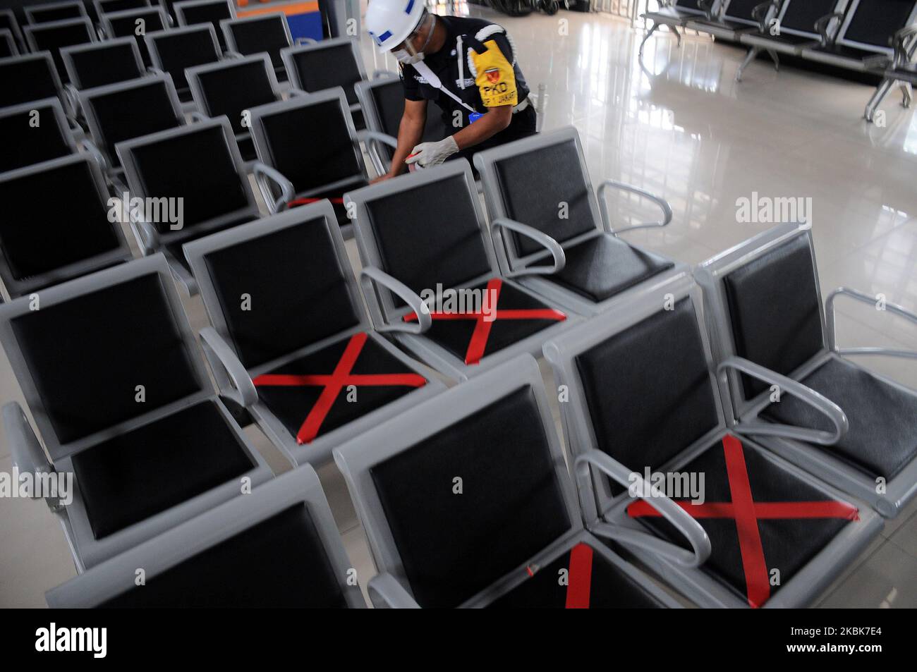 Zugbeamte legten Kreuzaufkleber auf die Wartesessel am Bahnhof Pasar Senen, Jakarta, Am 19,2020. März soll den Bahnbenutzern ein beschränkendes Zeichen zur Verfügung gestellt werden, um ihre Distanz zu anderen Fahrgästen zu halten, um soziale Distanzierungsrufe umzusetzen, die die Ausbreitung des Corona-Virus (covid-19) hemmen und die Körpertemperatur potenzieller Fahrgäste überprüfen sollen In der Nähe des Bahnhofs Pasar Senen. (Foto von Dasril Roszandi/NurPhoto) Stockfoto