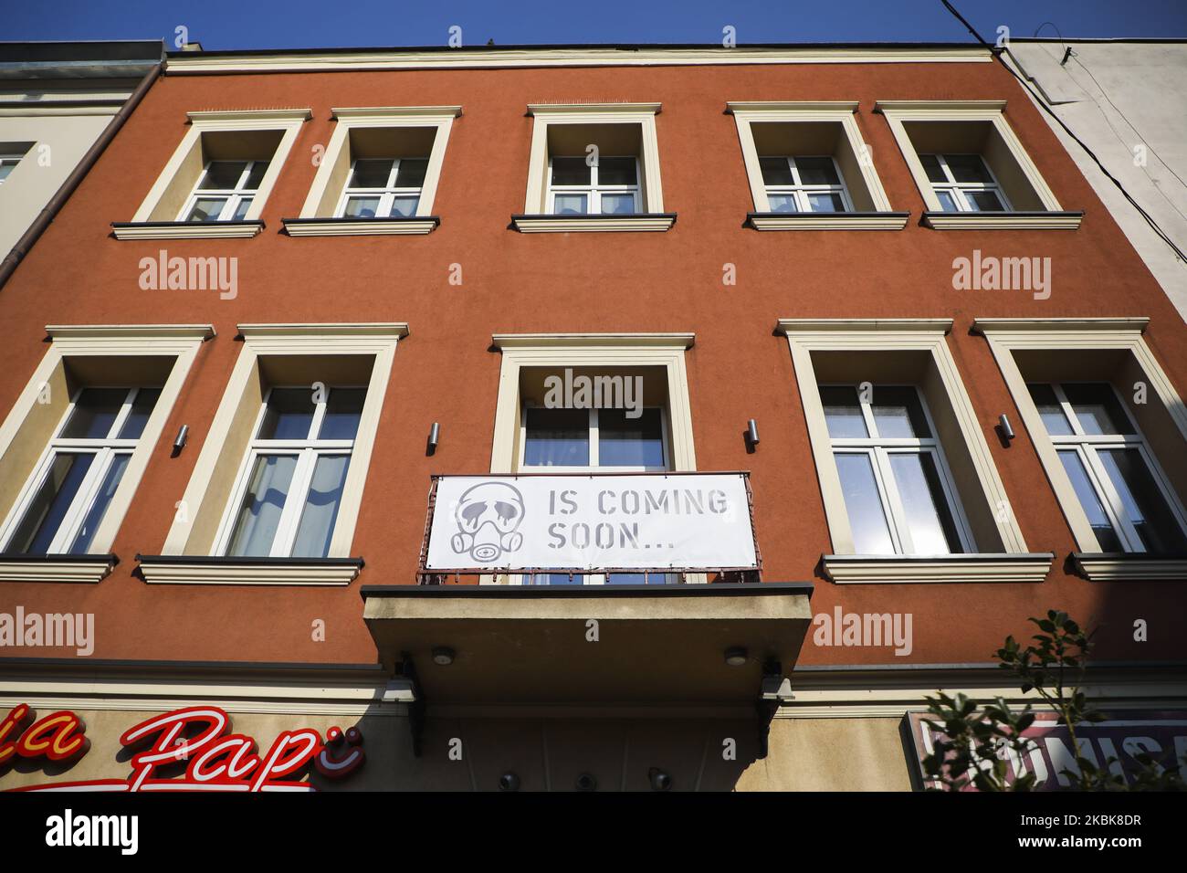 Am 19. März 2020 ist auf einem Balkon in Krakau, Polen, ein Banner mit einer Gesichtsmaskengrafik und dem Schild „kommt bald...“ zu sehen. Aufgrund der Ausbreitung des Coronavirus hat der polnische Premierminister einen Ausnahmezustand eingeführt, der die Schließung von Schulen und Universitäten, Kontrollen an den Grenzen des Landes und Beschränkungen für Dienstleistungen wie Museen, Restaurants, Pubs und Einkaufszentren umfasst. (Foto von Beata Zawrzel/NurPhoto) Stockfoto