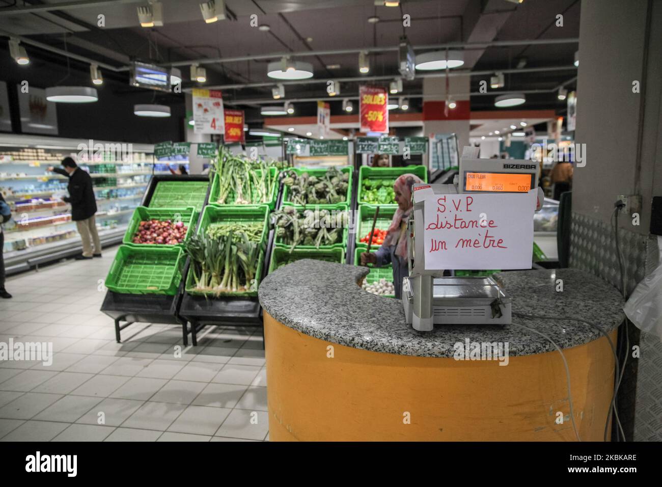 Ein Plakat mit der Aufschrift ‘„Please a distance of 1 meters“ wird als Erinnerung an den Sicherheitsabstand aufgestellt, den Menschen am 16. März 2020 in einem Supermarkt beobachten müssen, um das Coronavirus COVID-19 in der Stadt Ariana, Nordtunesien, zu verhindern. (Foto von Chedly Ben Ibrahim/NurPhoto) Stockfoto