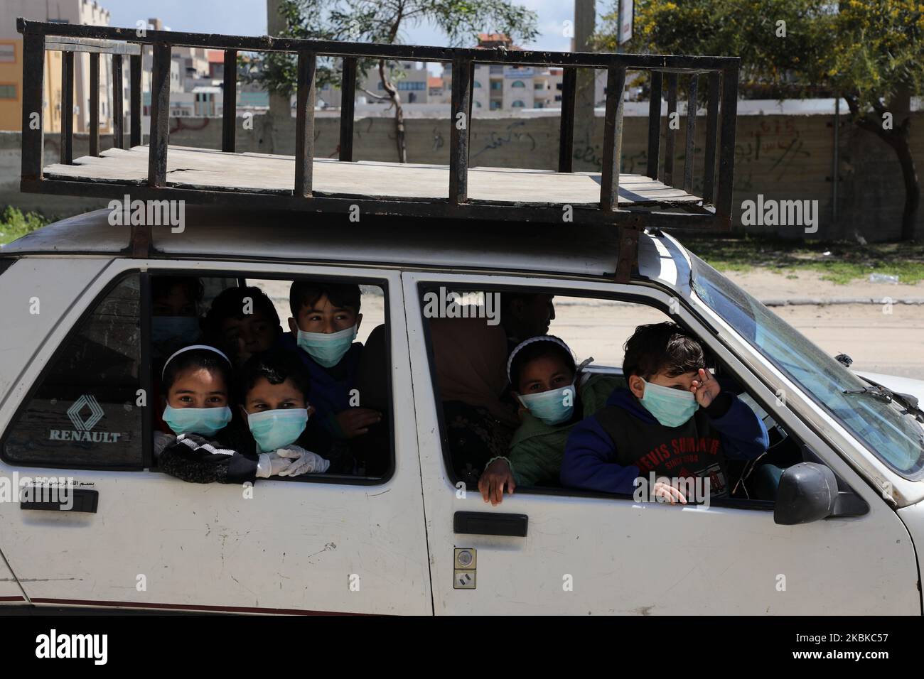 Palästinensische Kinder, die Gesichtsmasken tragen, wurden am 22. März 2020 in einem Auto in Gaza-Stadt gedeutet. - Die Behörden in Gaza bestätigten die ersten beiden Fälle von neuartigem Coronavirus, wobei die Personen als Palästinenser identifiziert wurden, die nach Pakistan gereist waren und bei ihrer Rückkehr in Quarantäne gehalten wurden. Die Vereinten Nationen haben davor gewarnt, dass ein Ausbruch der COVID-19 in Gaza angesichts der hohen Armutsraten und des schwachen Gesundheitssystems im Küstenstreifen, der seit 2007 durch die israelische Blockade blockiert wurde, katastrophal sein könnte. Die Behörden in Gaza haben gesagt, dass sich mehr als 2.700 Palästinenser in häuslicher Isolation befinden, vor allem Menschen, die zurückgebracht wurden Stockfoto