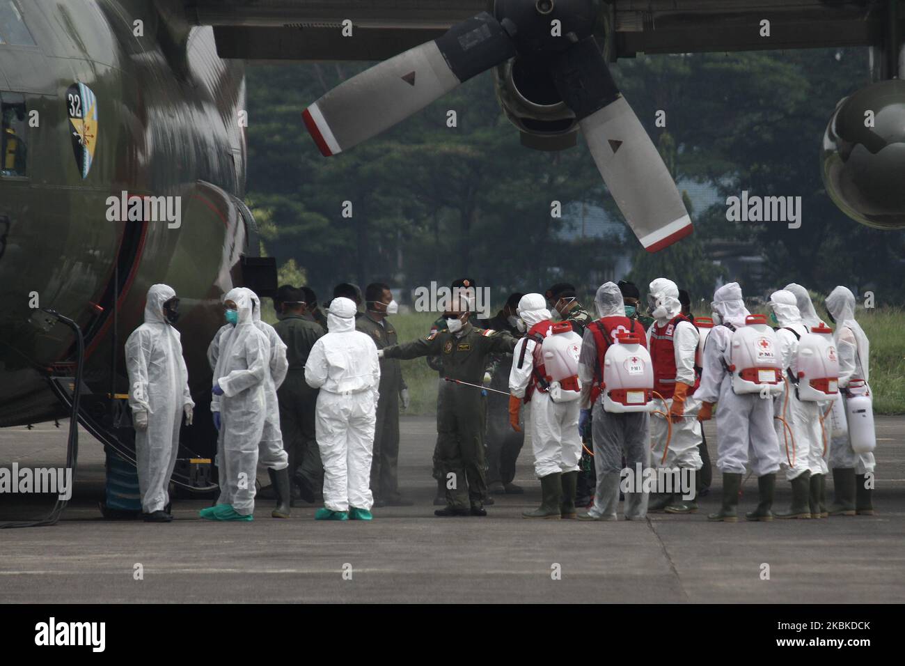 Gesundheitshelfer sprühen Desinfektionsmittel auf die Besatzungen von Militärflugzeugen der indonesischen Luftwaffe C-130, die 9 Tonnen medizinische Ausrüstung aus China transportieren, kurz nach der Landung auf dem halim Perdanakusuma Air Base, Jakarta, am 23. März 2020. Indonesien erhielt 9 Tonnen medizinische Ausrüstung von der chinesischen Regierung, um den Umgang mit dem COVID-19-Pandemi in Indonesien zu beschleunigen. (Foto von Aditya Irawan/NurPhoto) Stockfoto