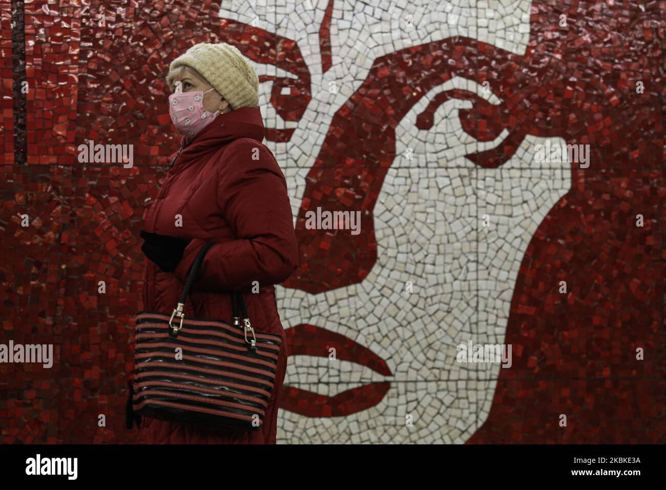Am 23. März 2020 geht eine Frau mit einer Töpfesmaske an einem Porträt des Dichters Wladimir Majakowski auf der Majakowskaja-Station in Sankt Petersburg, Russland, vorbei. Die Zahl der U-Bahn-Passagiere sank aufgrund des Coronavirus-Ausbruchs um 30 %. (Foto von Valya Egorshin/NurPhoto) Stockfoto