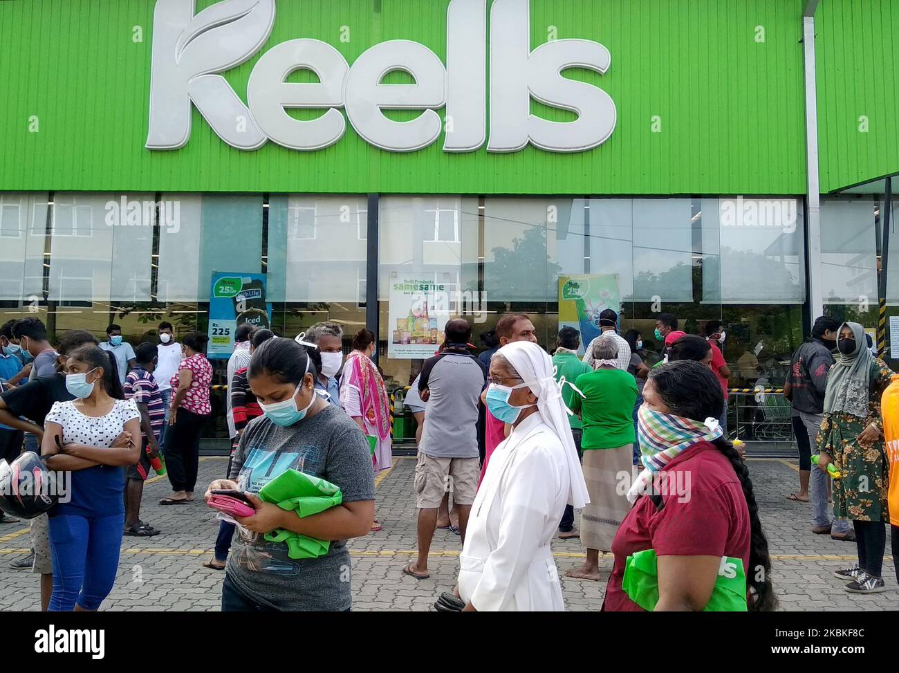 Eine Sri-lankische katholische Nonne mit einer schützenden Gesichtsmaske wartet am 24. März 2020 in einer langen Schlange mit maskierten Sri-Lankern in der Nähe eines Super Market Rajagiriya in Colombo, Sri Lanka. (Foto von Tharaka Basnayaka/NurPhoto) Stockfoto