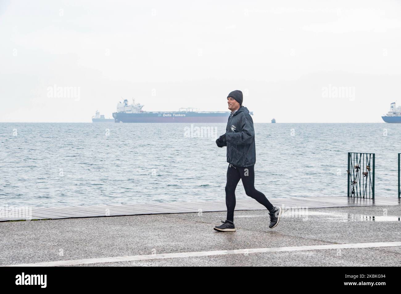 Ein Mann, wie man sieht, der allein am Wasser und an der neuen Promenade von Thessaloniki, Griechenland, in Isolation von anderen Menschen, soziale Distanzierung wegen der allgemeinen Quarantäne im Land läuft. Tag drei der totalen Sperrung des Landes. Alle Menschen, die sich außerhalb ihrer Häuser befinden, werden von der Polizei auf die speziellen Genehmigungsdokumente oder SMS und ID überprüft, die es ihnen ermöglichen, sich außerhalb zu befinden. Die griechische Regierung und der Premierminister Kyriakos Mitsotakis haben die Schließung des Landes mit der Schließung von Geschäften und Verkehrsbeschränkungen als starke Präventivmaßnahme gegen die Region eingeführt Stockfoto