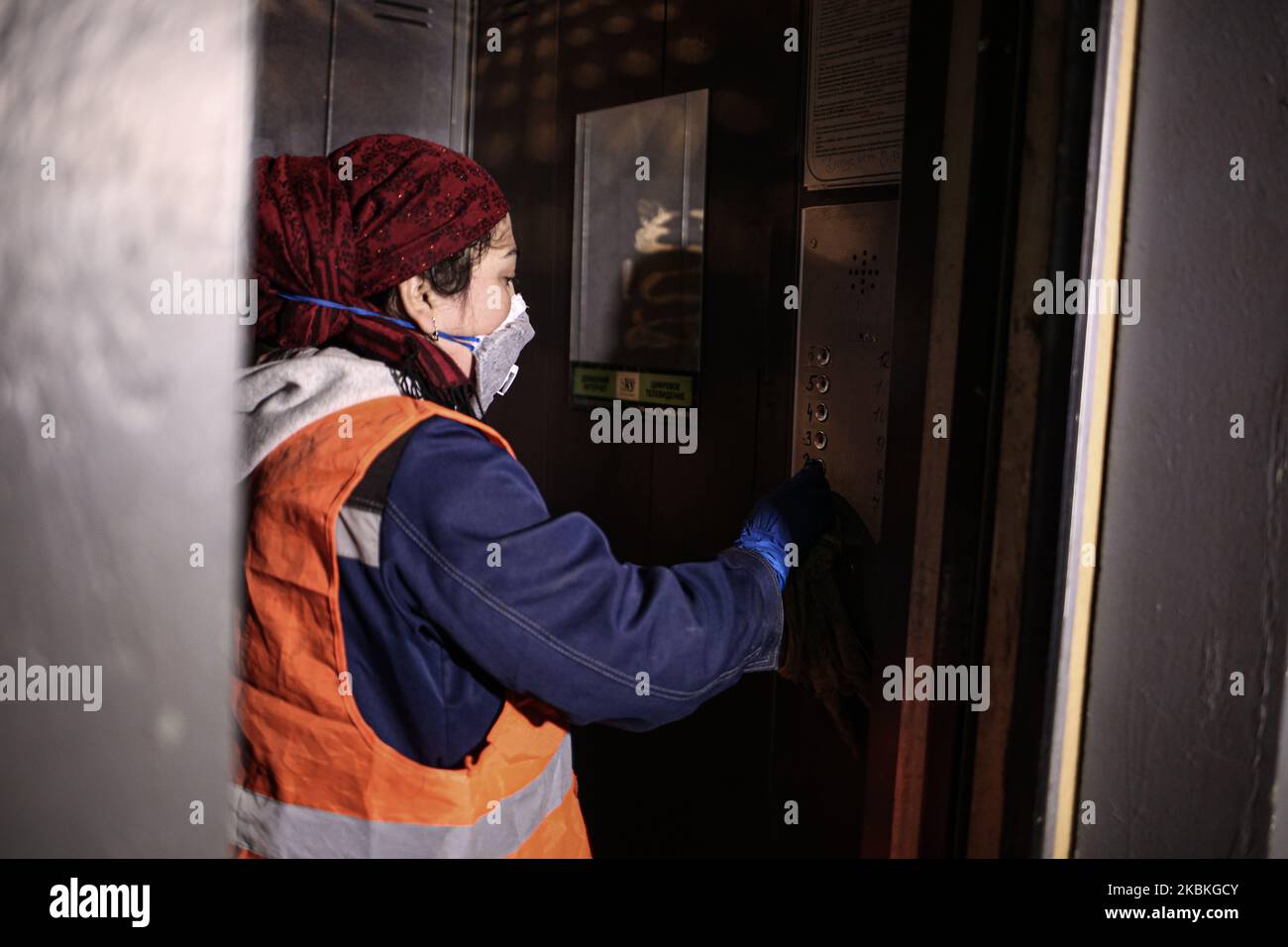 Ein Mitarbeiter des Stadtdienstes reinigt und desinfiziert den Eingang eines Wohnhauses in Sankt Petersburg, Russland, 25. März 2020. Desinfizieren Sie die Tasten, Türgriffe und Geländer des Aufzugs. In Russland gibt es 495 Menschen, die mit dem Coronavirus infiziert sind. (Foto von Valya Egorshin/NurPhoto) Stockfoto