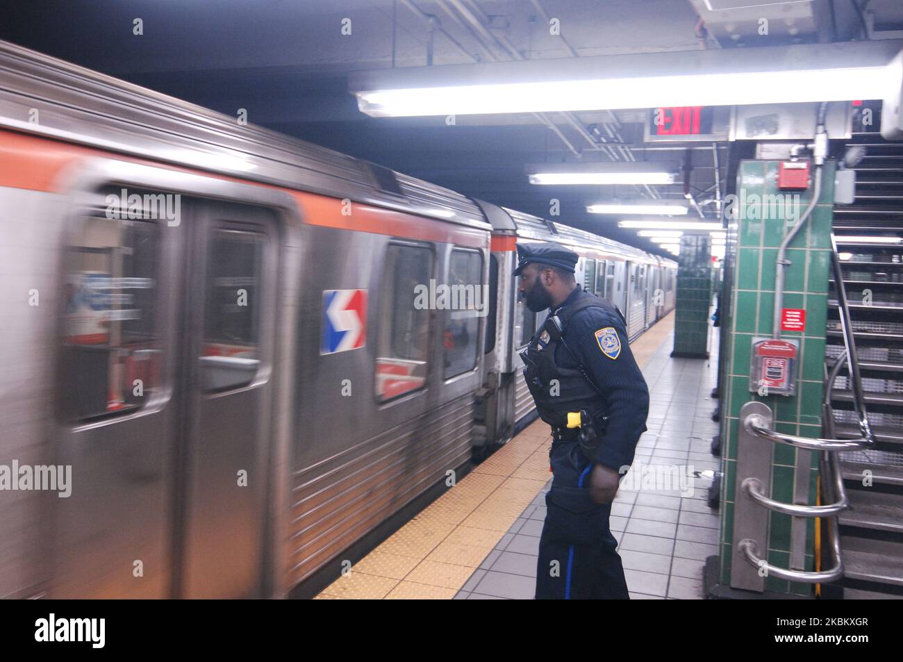 Ein Polizeibeamter wartet auf die Haltestelle der Broad Street Line am Bahnhof Erie, damit er eine Obdachlose aufwecken kann, die im Zug schläft, während der Coronavirus-Pandemie und der Stadtversagen zum Schutz der schutzbedürftigen Obdachlosen in Philadelphia, PA, am 1. April 2020. (Foto von Cory Clark/NurPhoto) Stockfoto