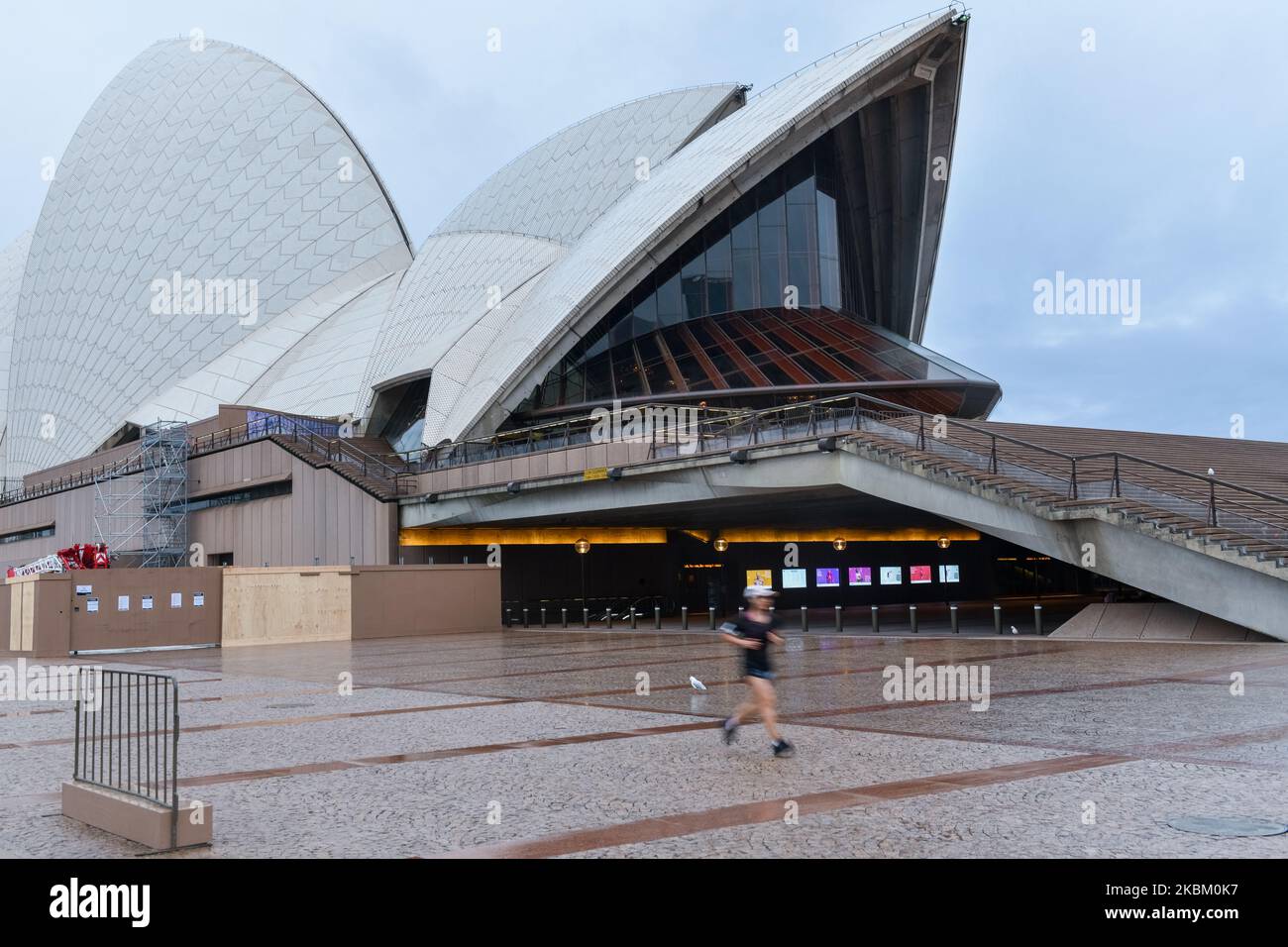 Ein Jogger läuft mit dem „Spirit of Winning“, der vor dem leeren Opernhaus von Sydney inmitten des Coronavirus-Ausbruchs am 05. April 2020 in Sydney, Australien, zu sehen ist. (Foto von Izhar Khan/NurPhoto) Stockfoto