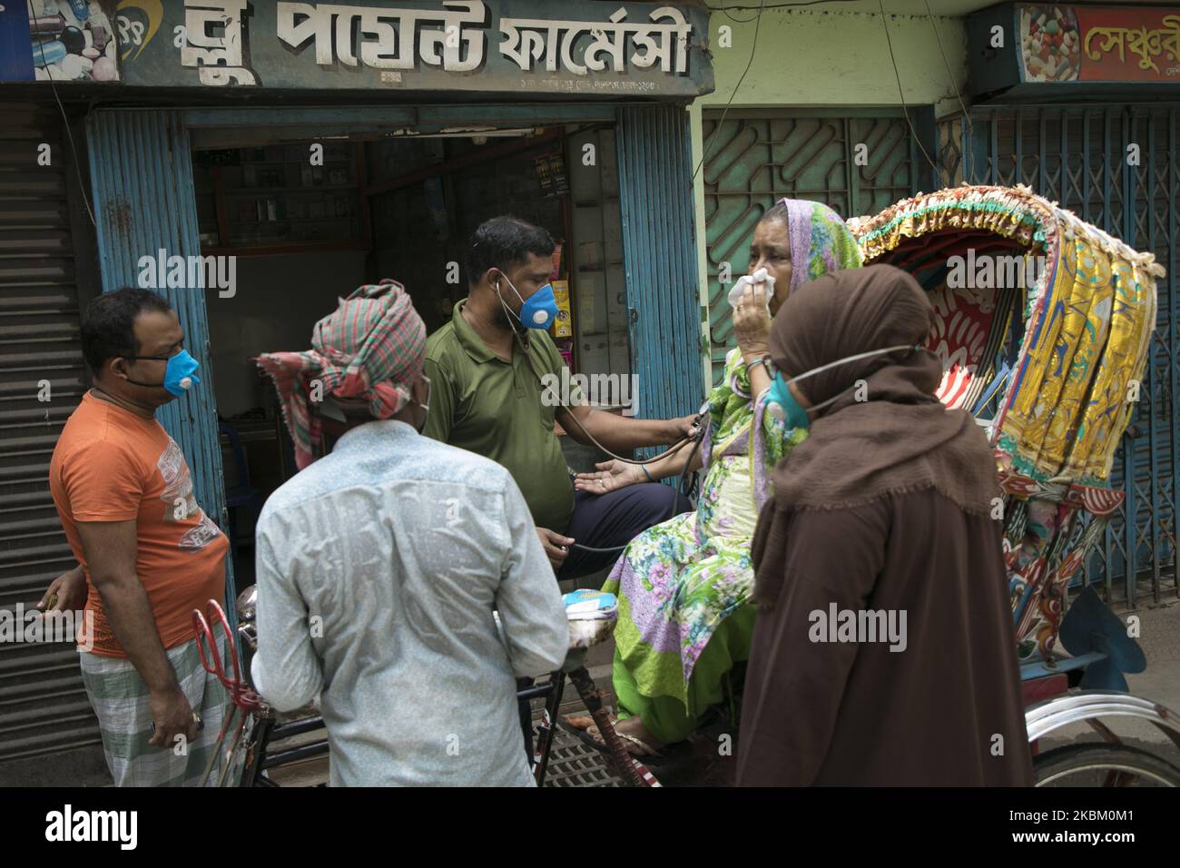 Eine Patientin, die ihren Blutdruck auf der Straße zählt, vor einer Apotheke im alten Dhaka während der von der Regierung auferlegten Sperre als vorbeugende Maßnahme gegen das COVID-19-Coronavirus in Dhaka, Bangladesch, am 05. April 2020. (Foto von Zakir Hossain Chowdhury/NurPhoto) Stockfoto