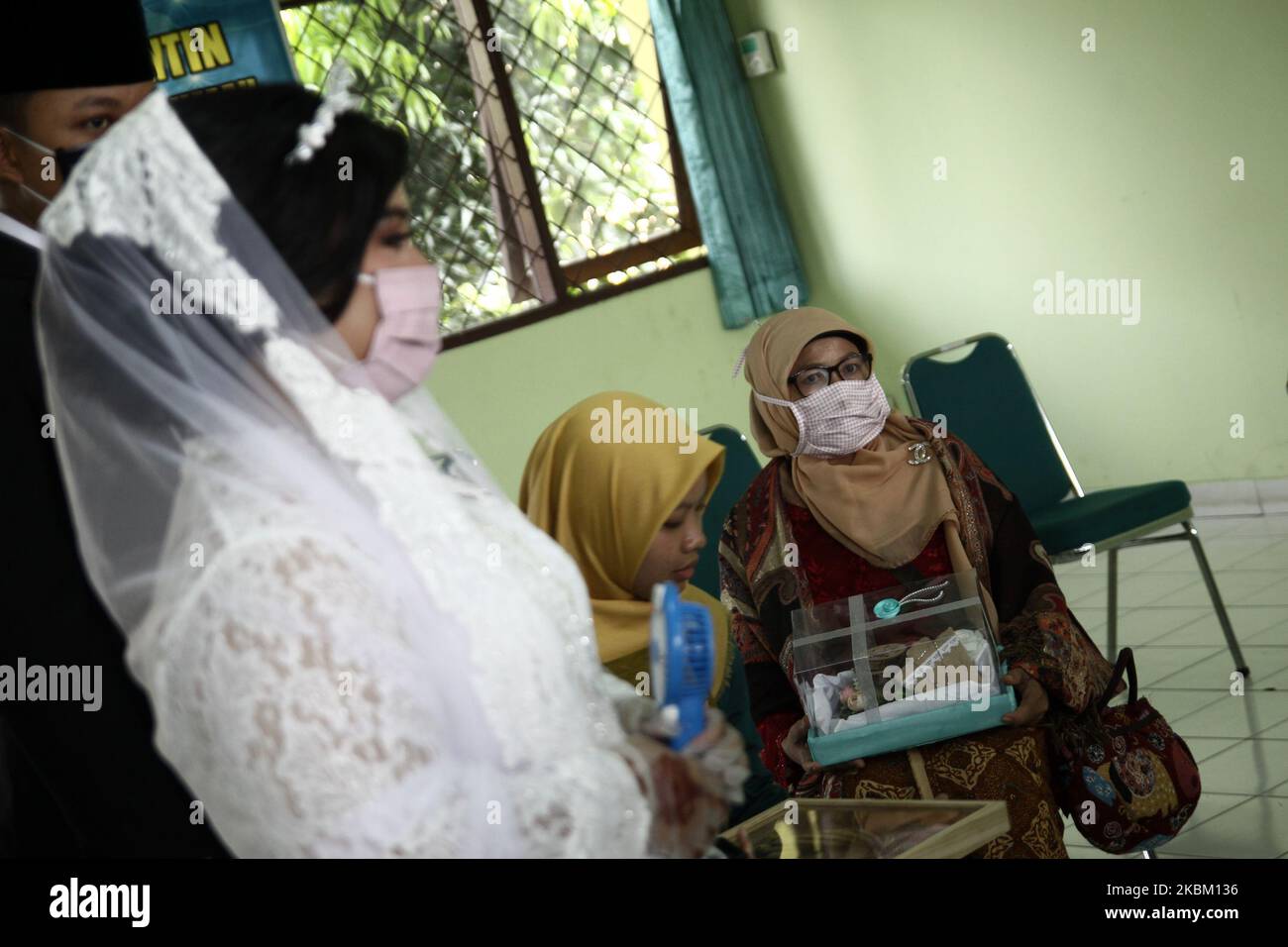 Das Ehepaar kaaried ihre Ehe am 5. April 2020 in Jakarta mit einer Gesichtsmaske und Latexhandschuhen aus Sorge um das Coronavirus (Covid-19). Die indonesische Regierung strickte die Politik der physischen Distanzierung, nachdem die Zahl der Coronavirus-Fälle weiter anstieg, die im April 4 über 2,092 Fälle im ganzen Land mit 191 Todesfällen und 150 Genesungen lagen. (Foto von Aditya Irawan/NurPhoto) Stockfoto