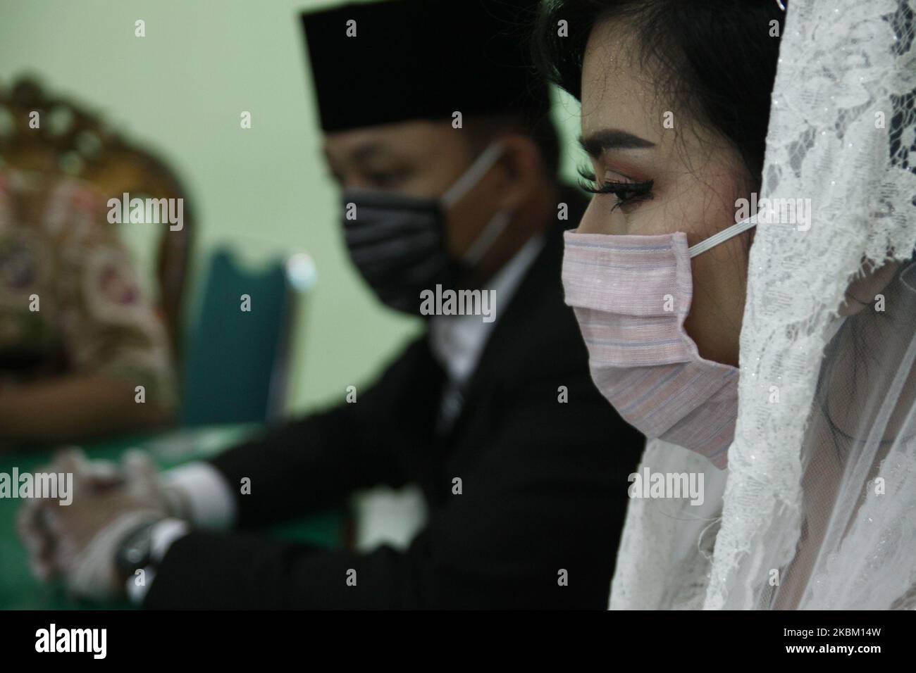 Das Ehepaar kaaried ihre Ehe am 5. April 2020 in Jakarta mit einer Gesichtsmaske und Latexhandschuhen aus Sorge um das Coronavirus (Covid-19). Die indonesische Regierung strickte die Politik der physischen Distanzierung, nachdem die Zahl der Coronavirus-Fälle weiter anstieg, die im April 4 über 2,092 Fälle im ganzen Land mit 191 Todesfällen und 150 Genesungen lagen. (Foto von Aditya Irawan/NurPhoto) Stockfoto